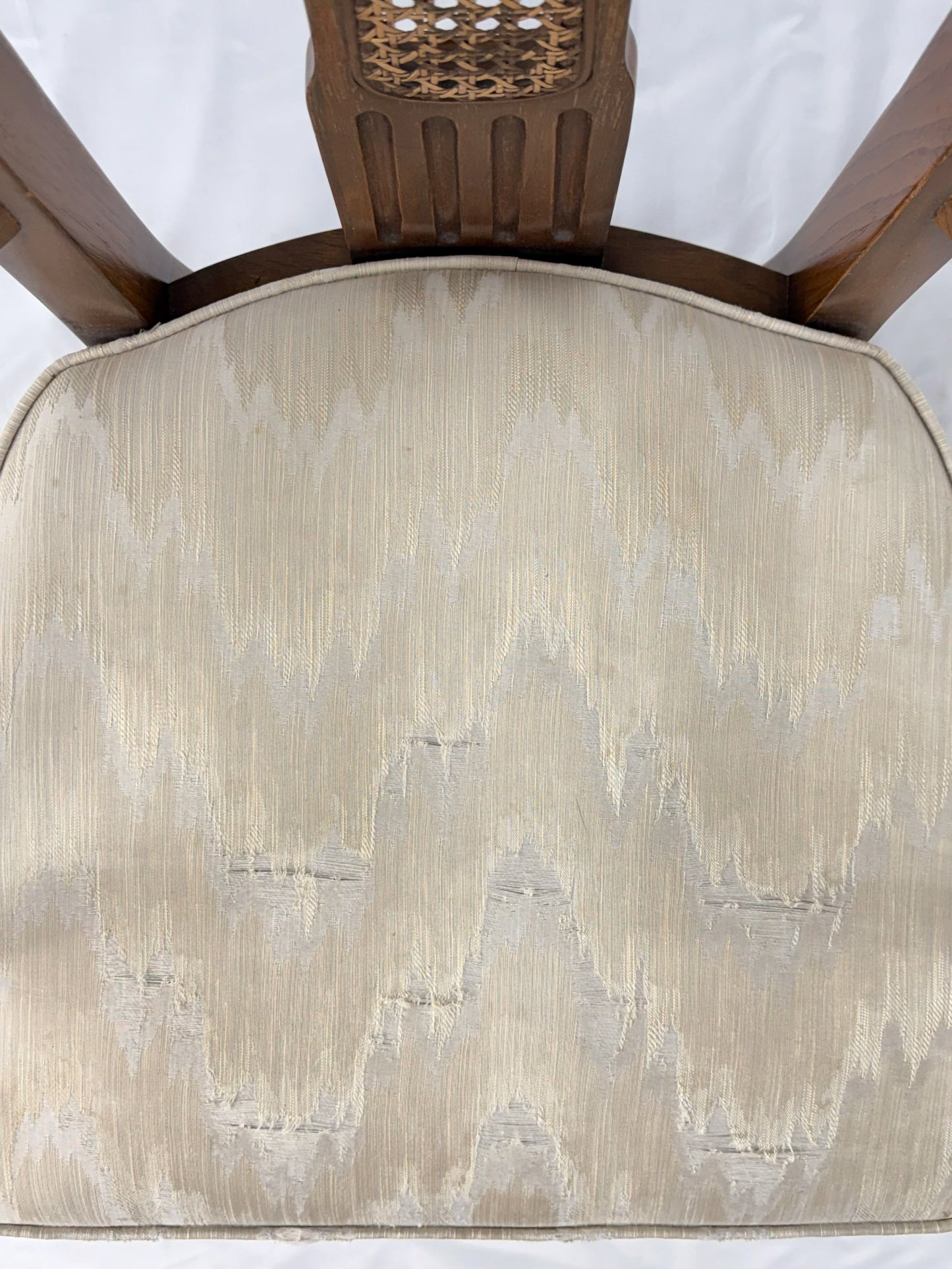 Wooden dining chair with a patterned cushion on a white background