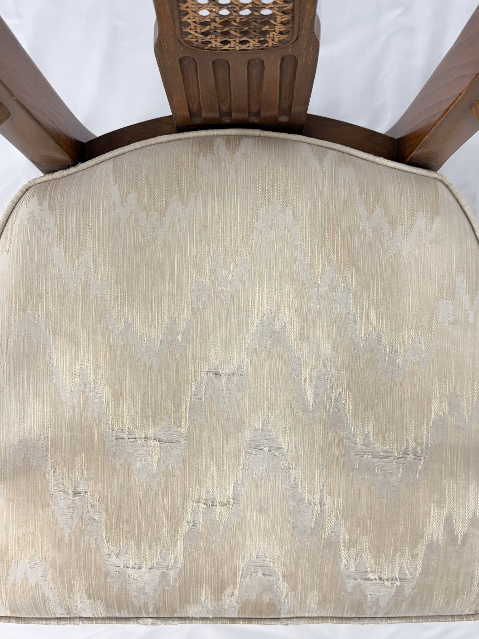 Wooden dining chair with a patterned cushion on a white background