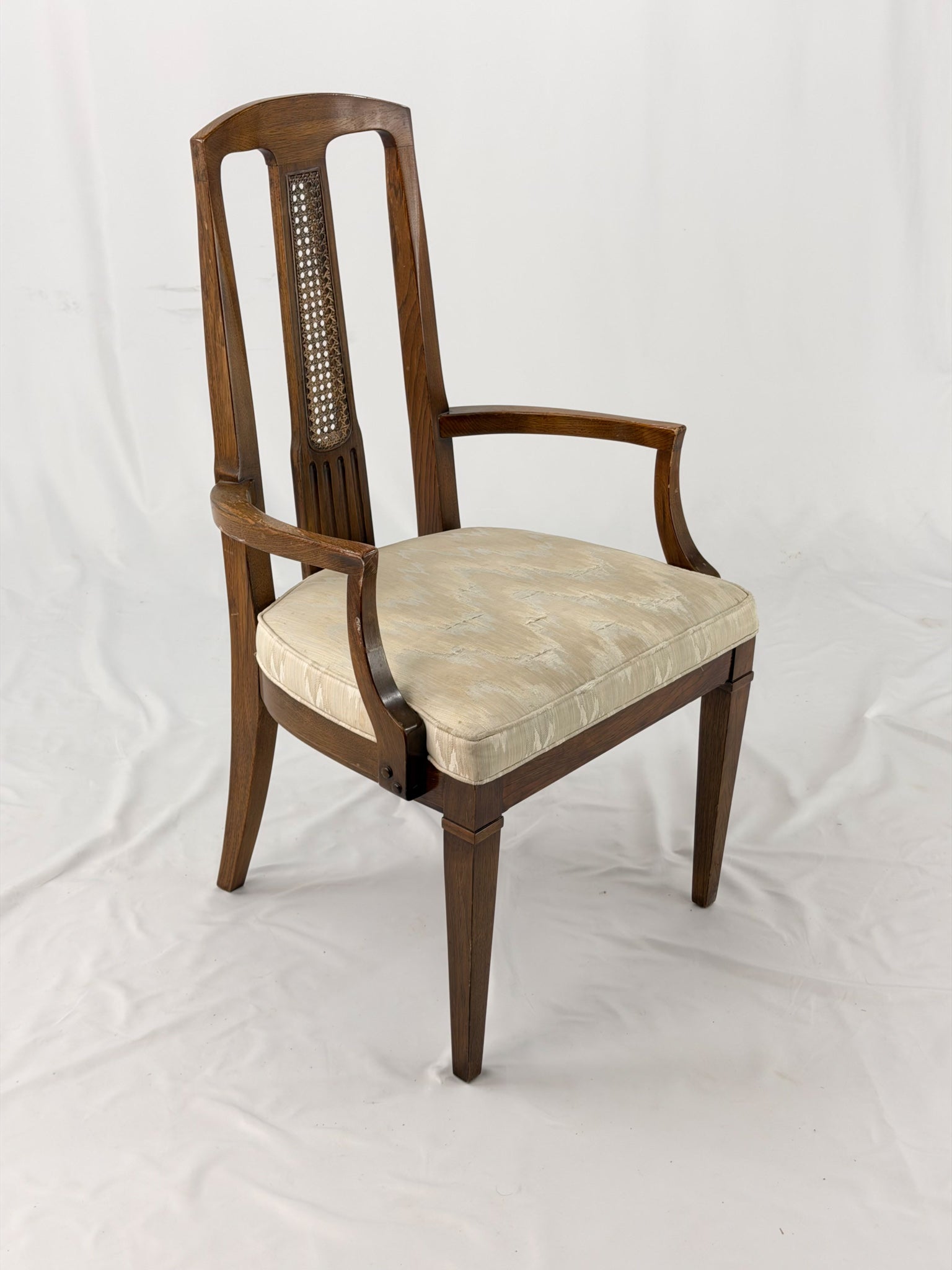 Wooden dining chair with a patterned cushion on a white background