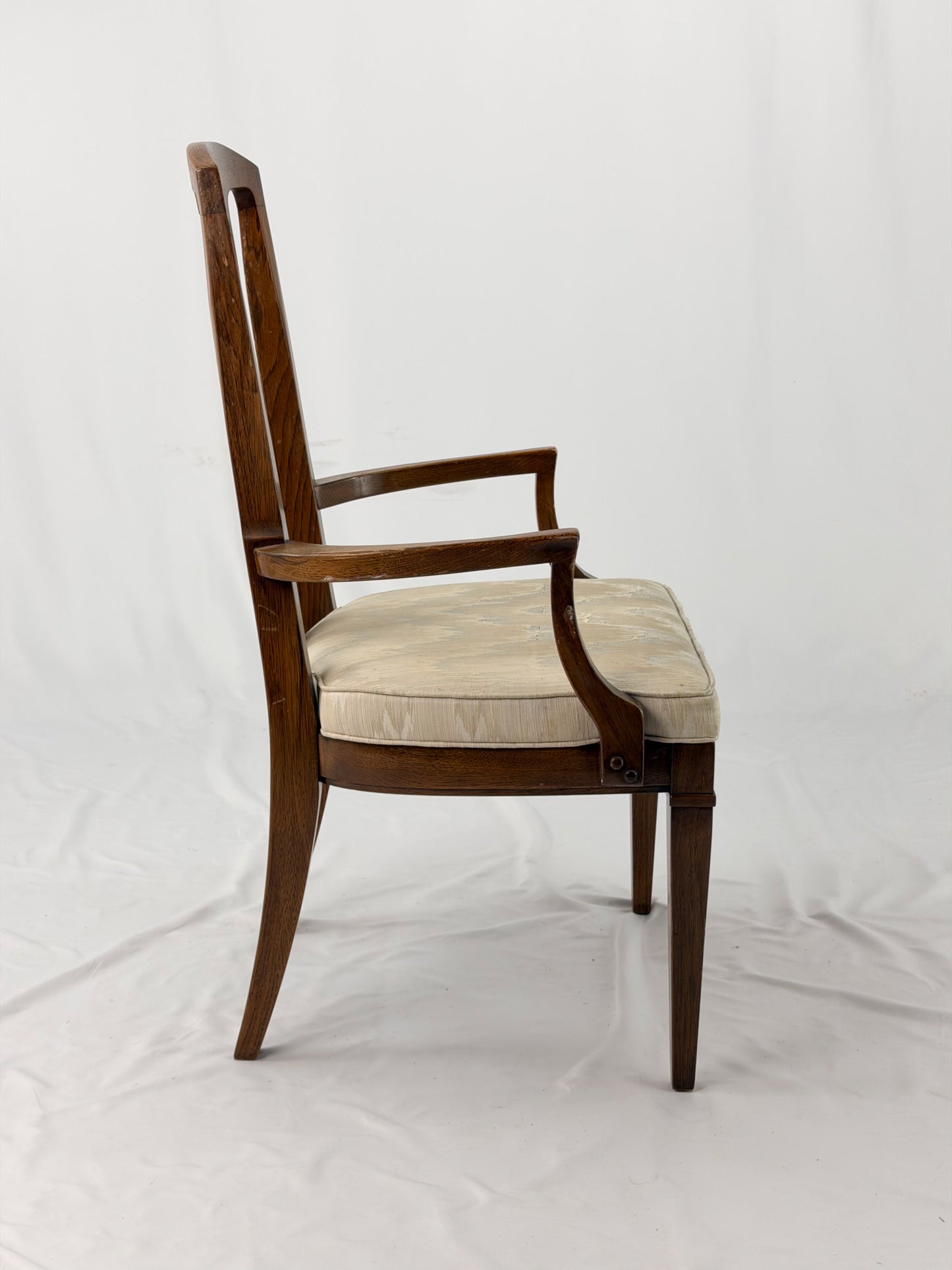 Wooden dining chair with a patterned cushion on a white background