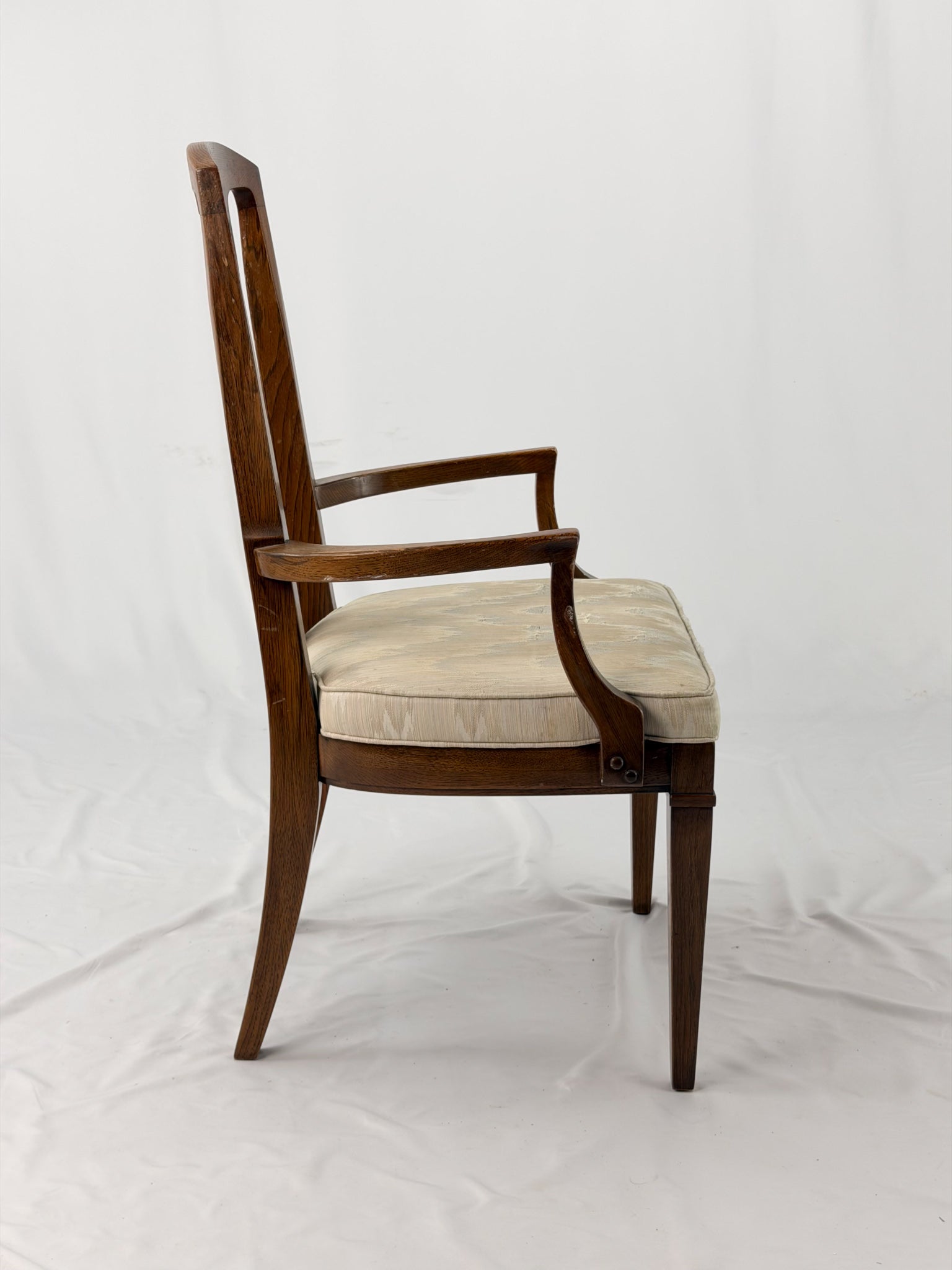 Wooden dining chair with a patterned cushion on a white background