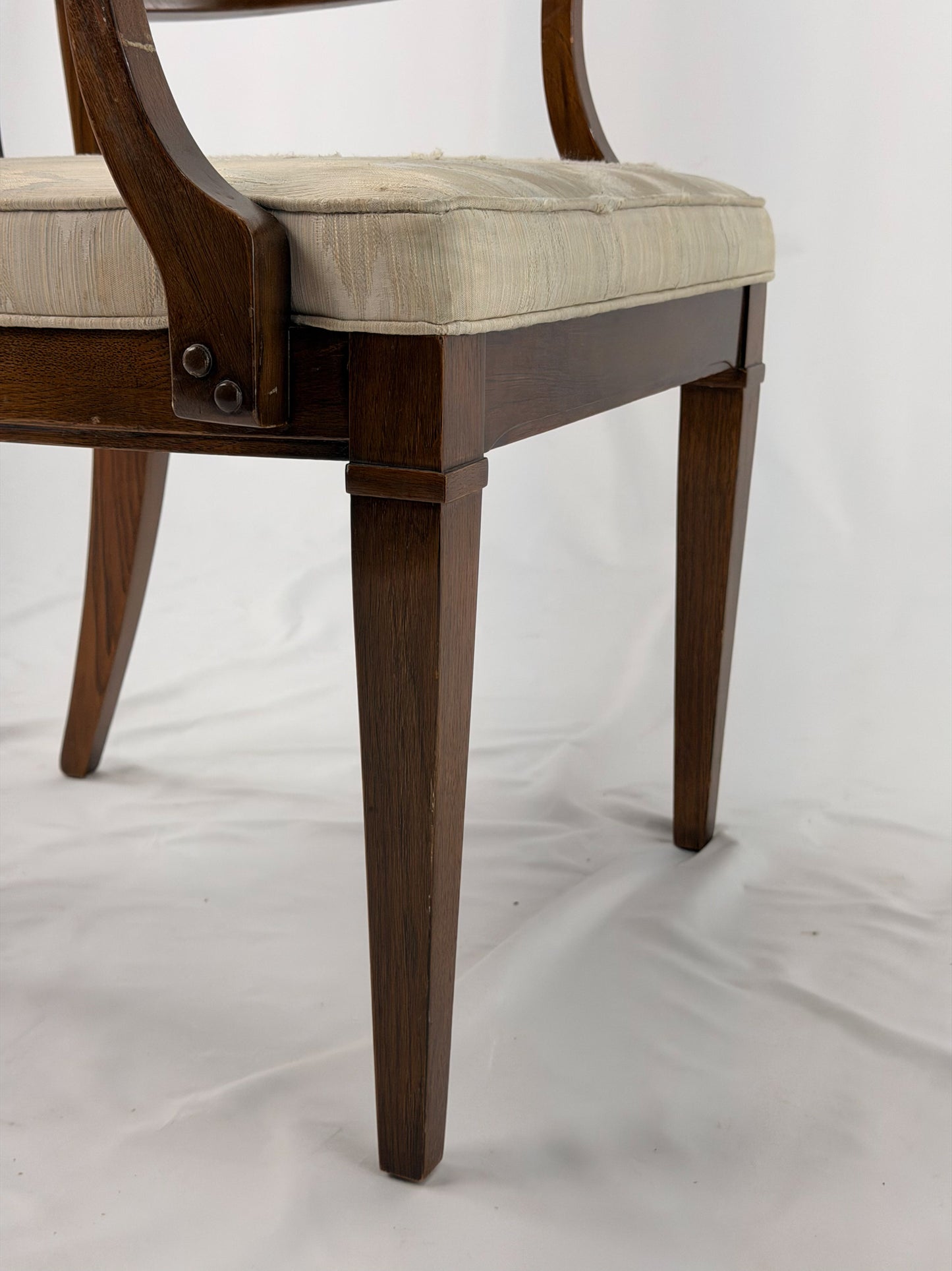 Wooden dining chair with a patterned cushion on a white background