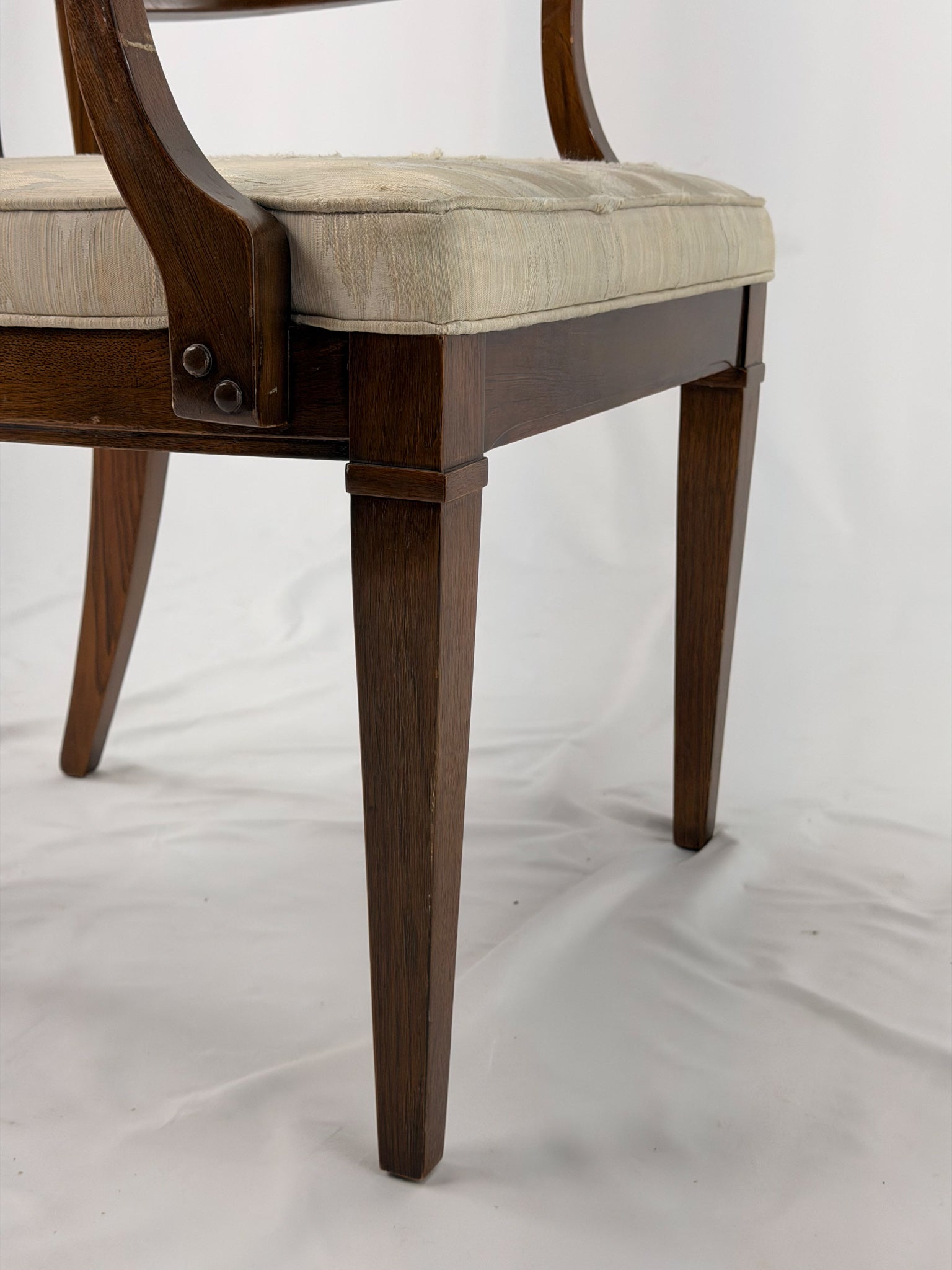 Wooden dining chair with a patterned cushion on a white background