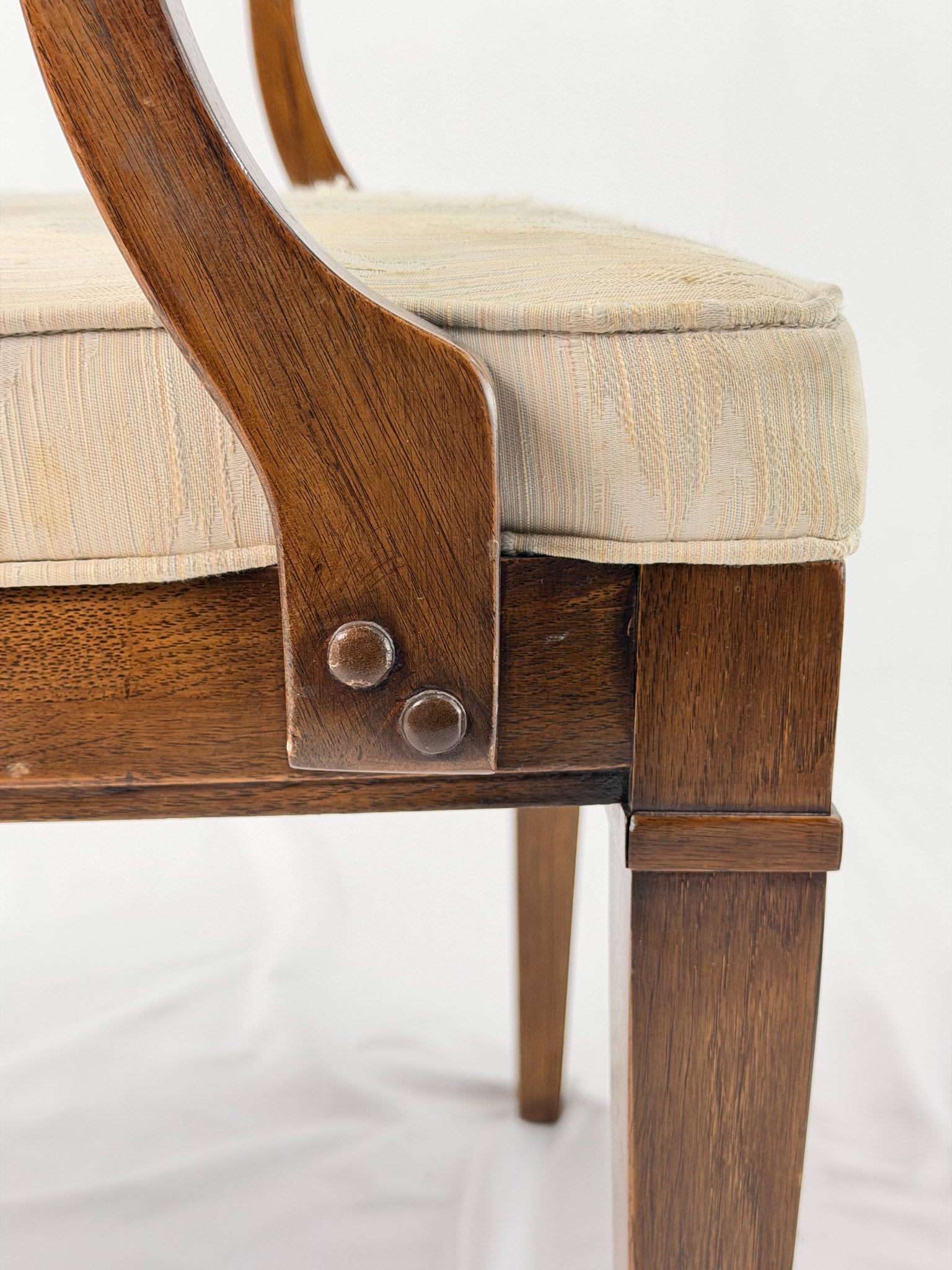 Wooden dining chair with a patterned cushion on a white background