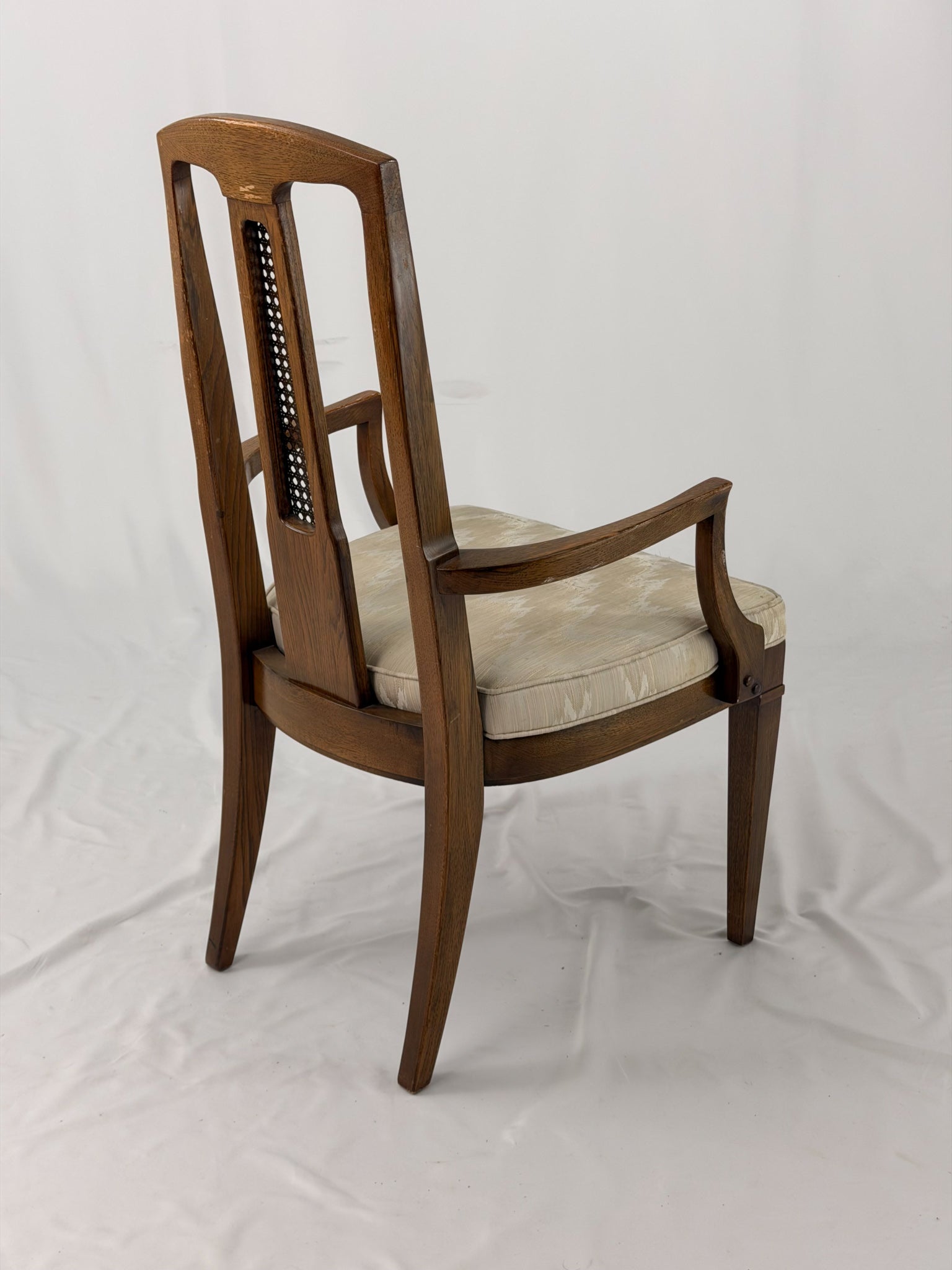 Wooden dining chair with a patterned cushion on a white background