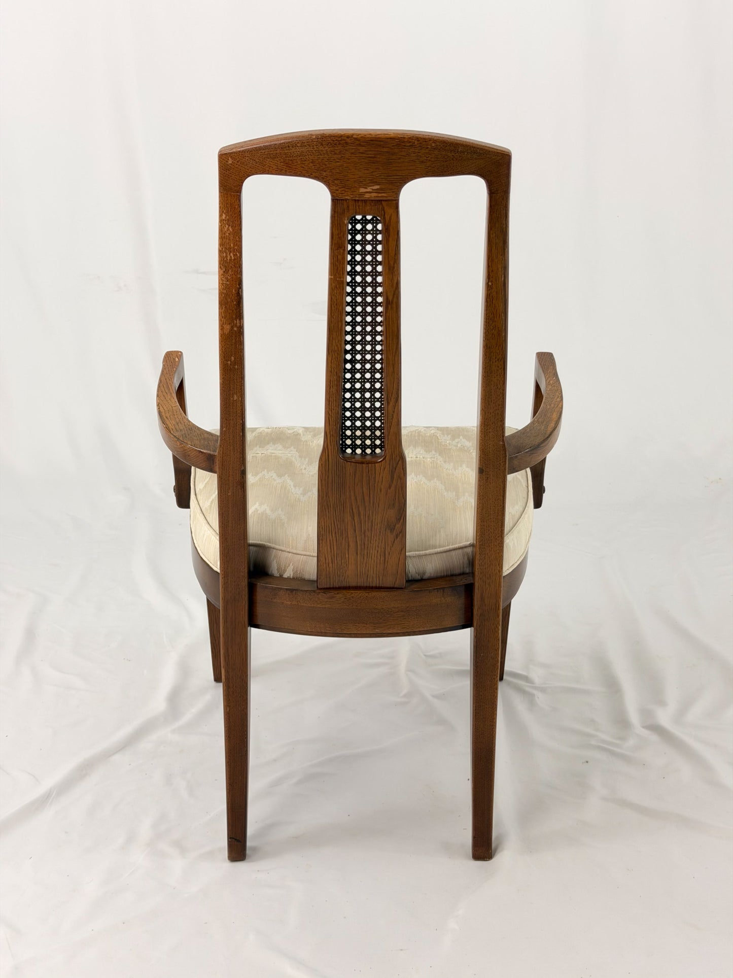 Wooden dining chair with a patterned cushion on a white background