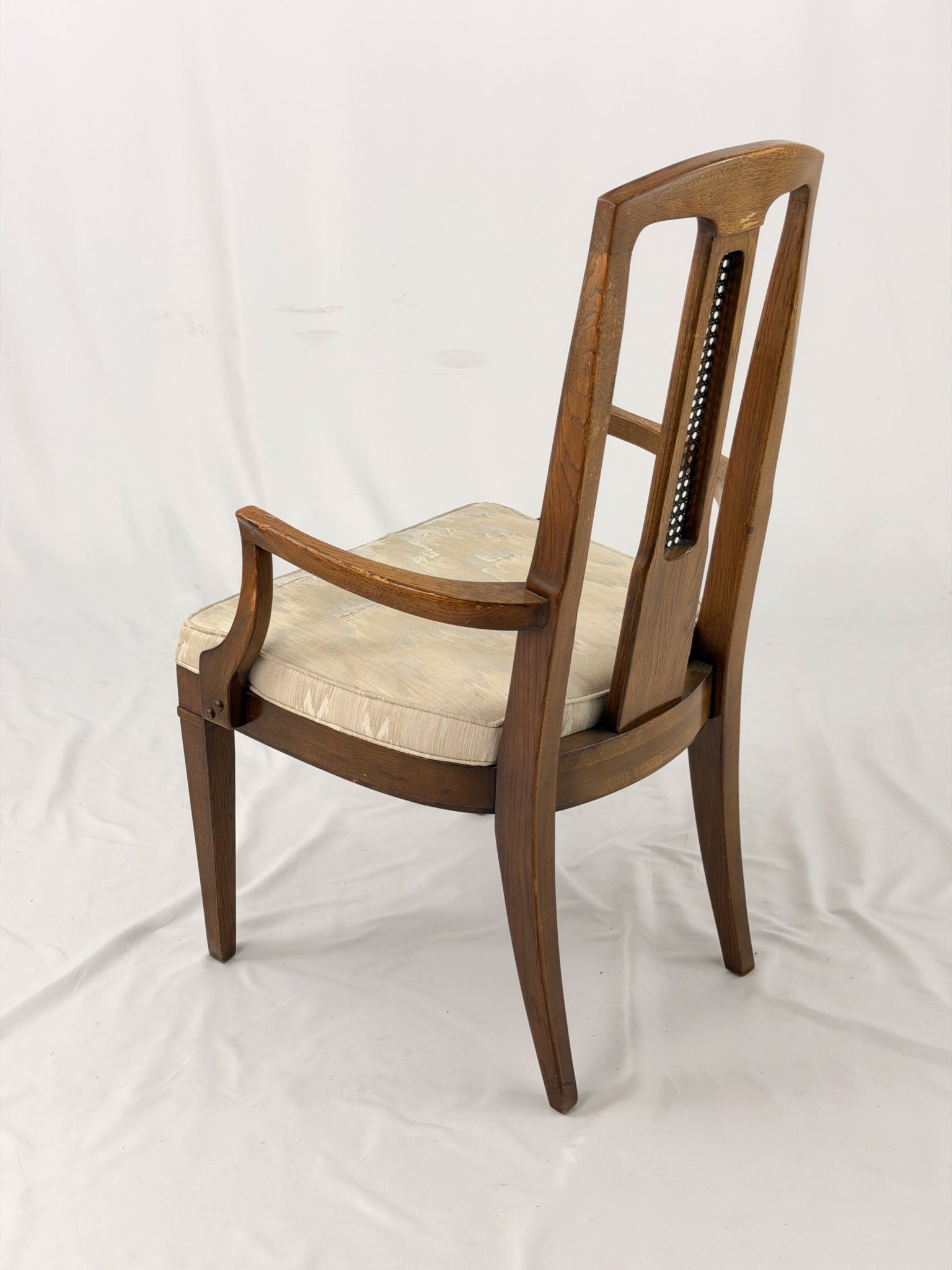 Wooden dining chair with a patterned cushion on a white background