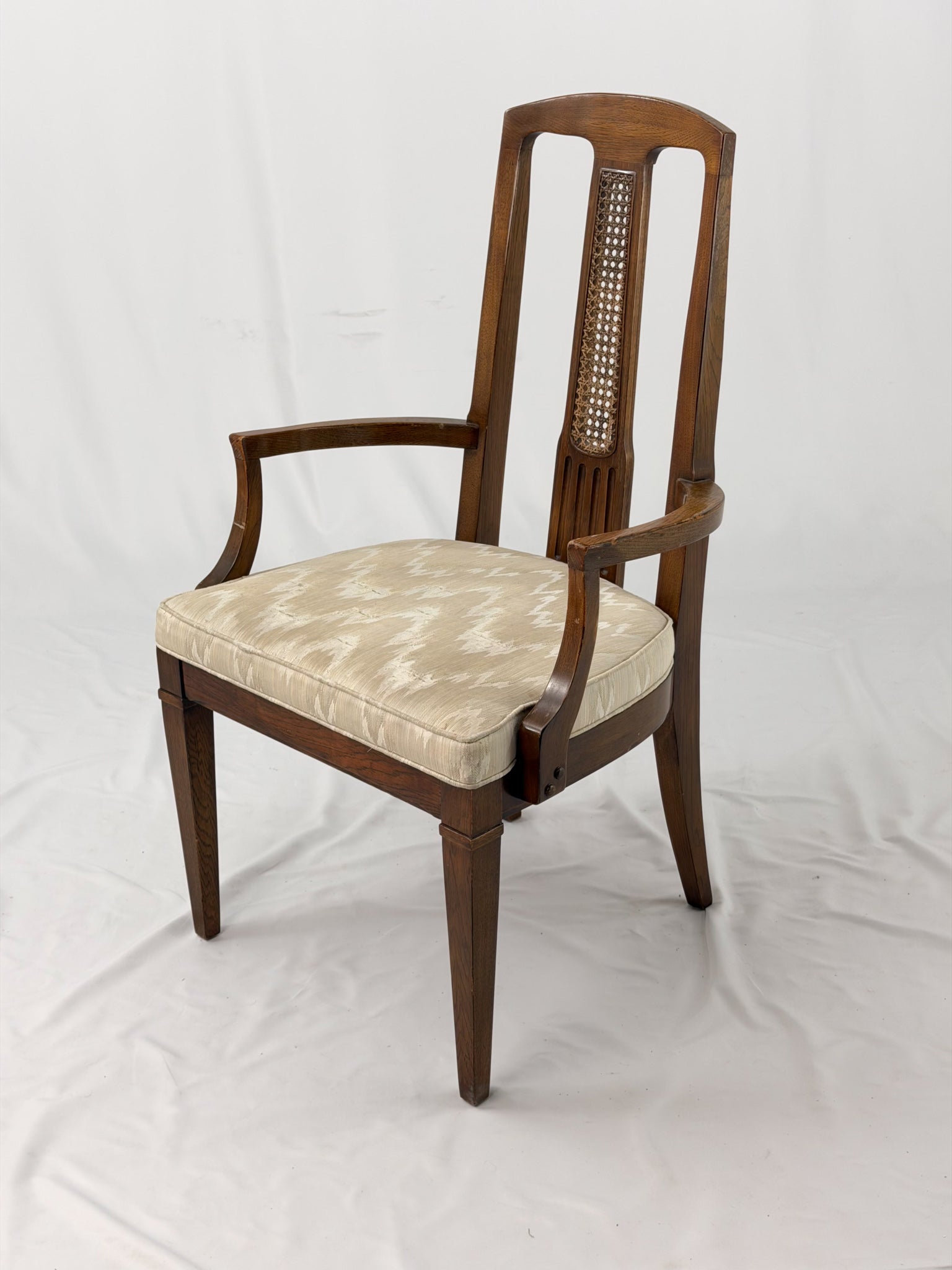Wooden dining chair with a patterned cushion on a white background