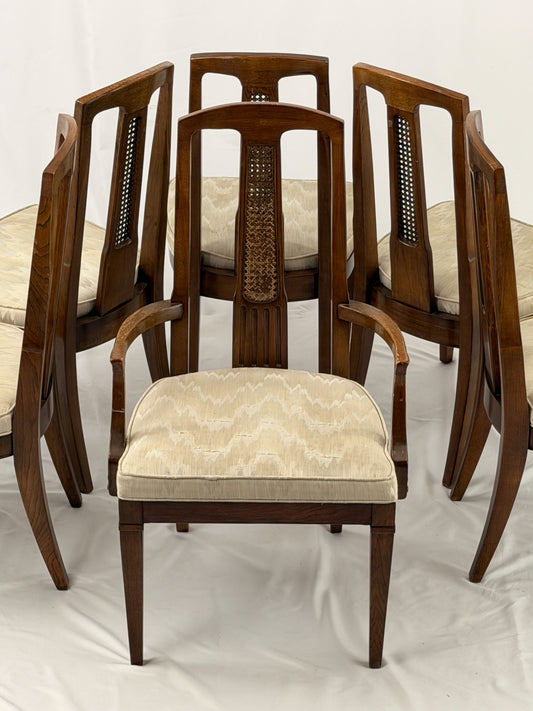 Set of six wooden chairs with beige cushioned seats on a white background