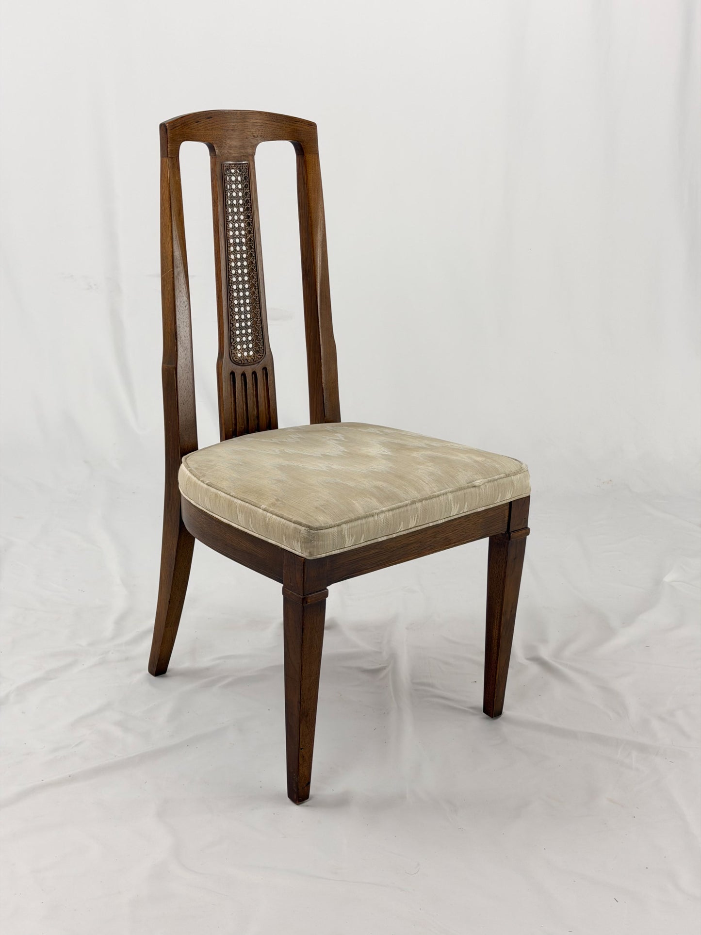 Wooden dining chair with a patterned cushion on a white background