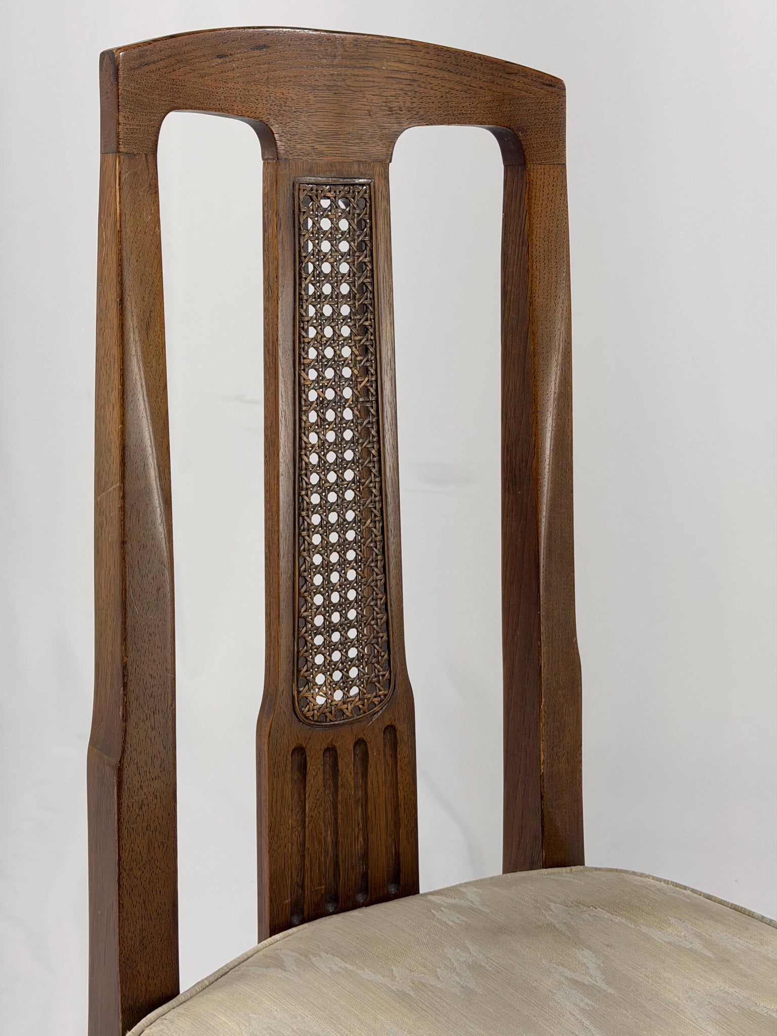 Wooden dining chair with a patterned cushion on a white background