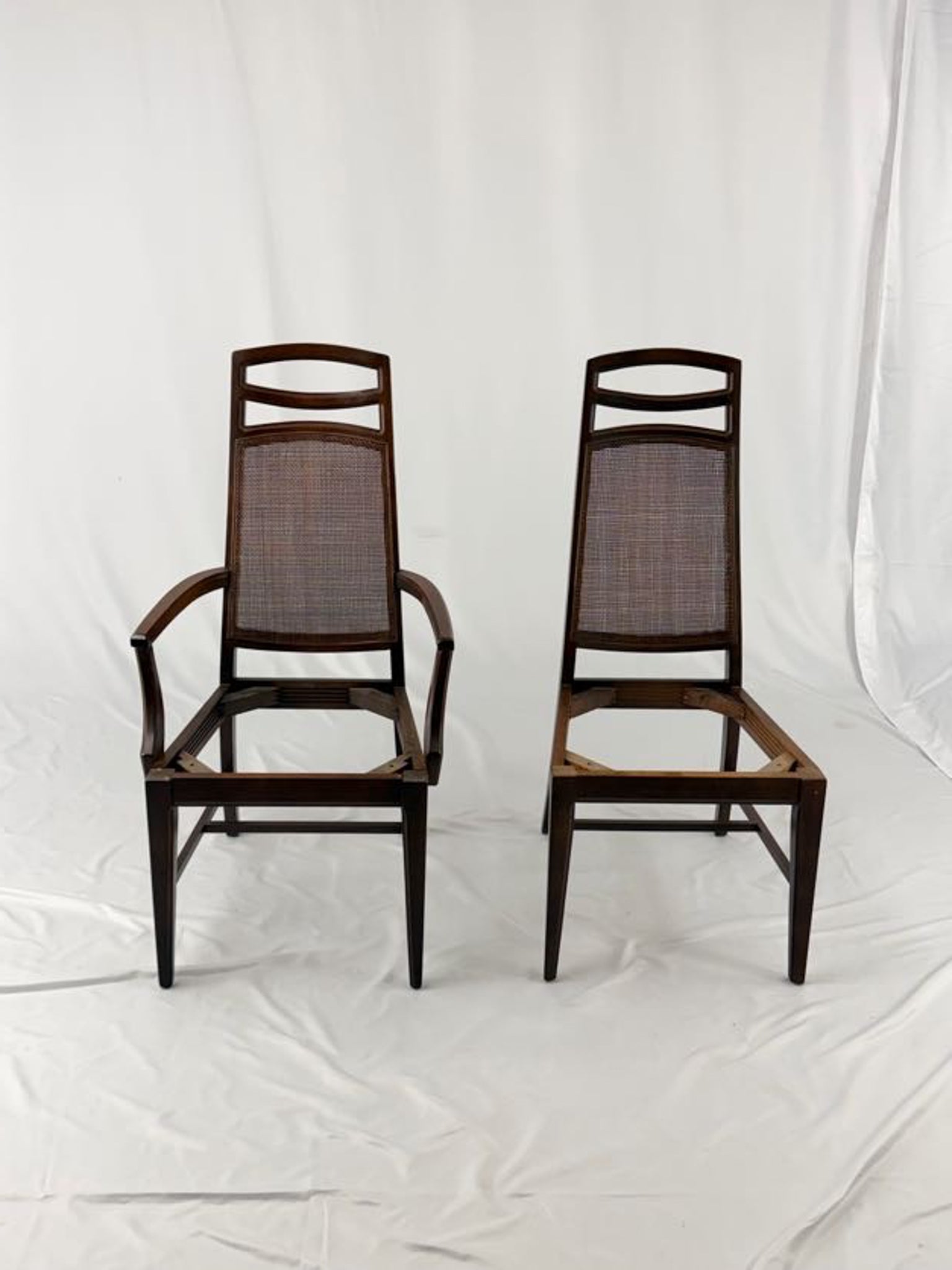 Two wooden chairs with woven backrests on a white background