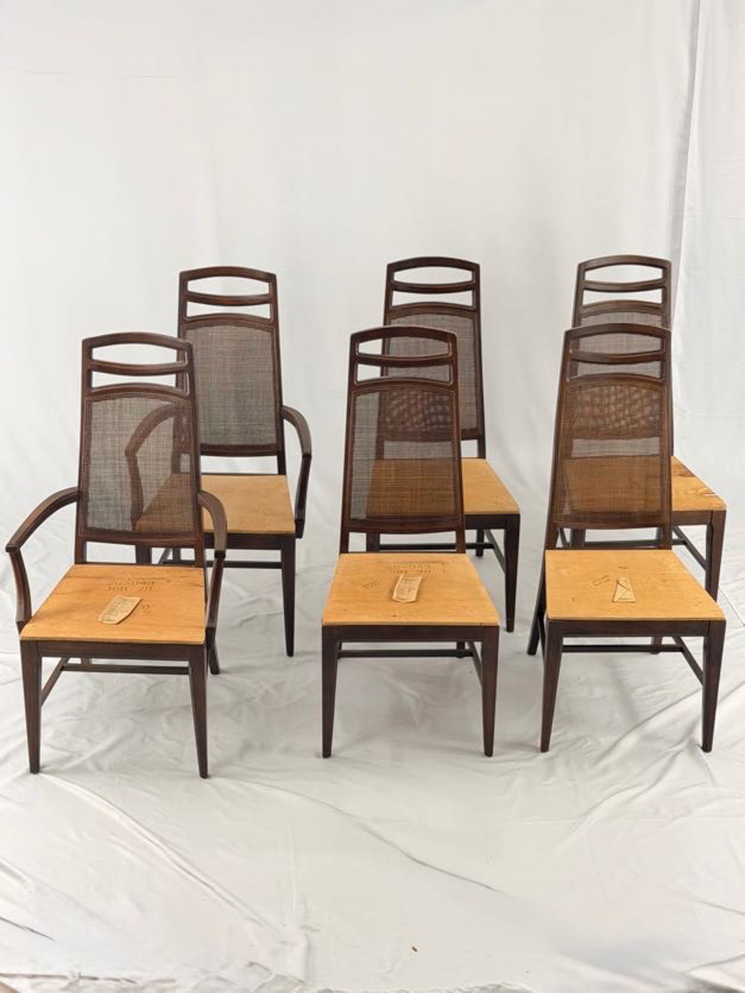 Set of six wooden chairs with woven backrests on a white background