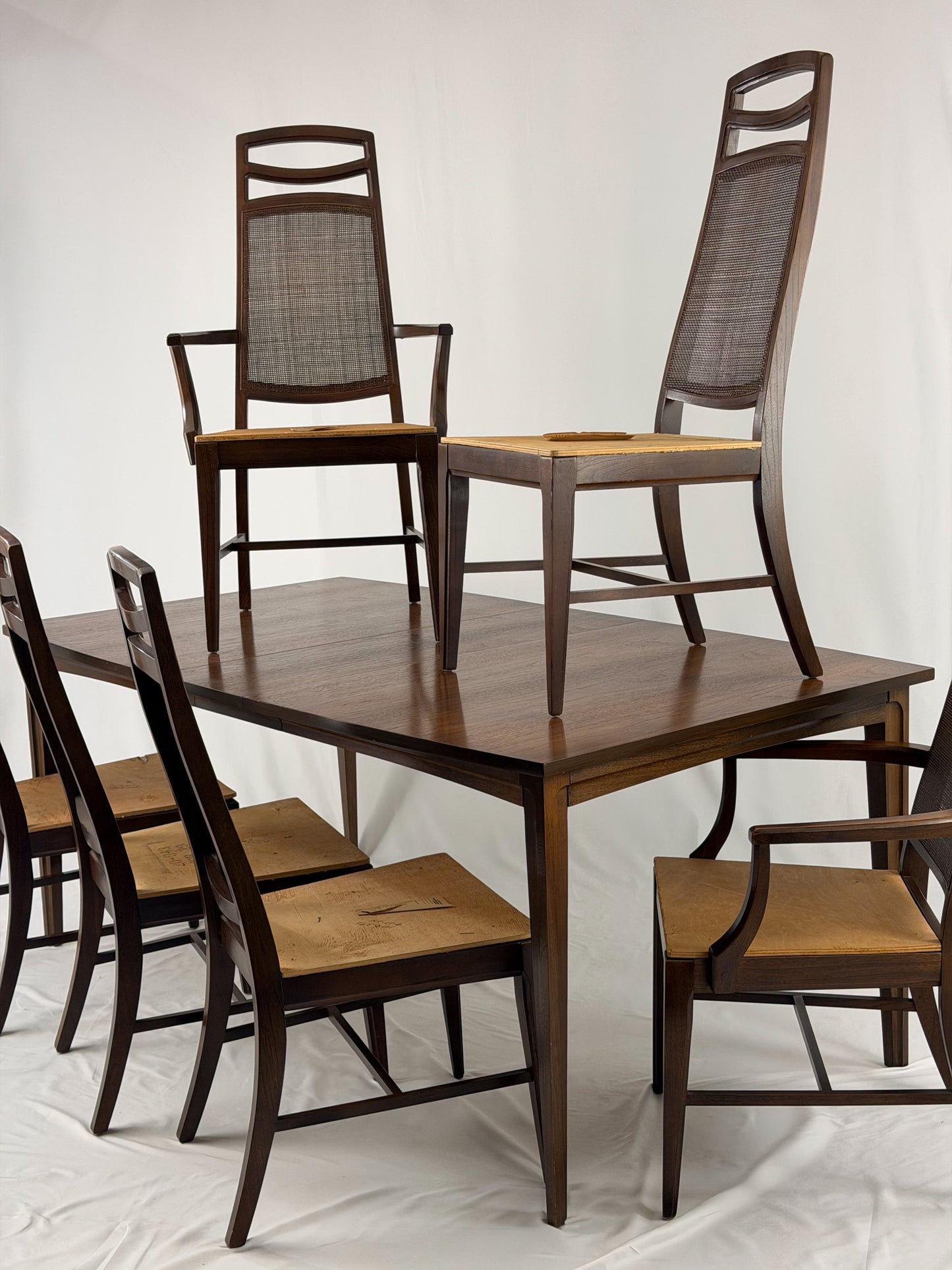 Wooden dining table with matching chairs on a white background