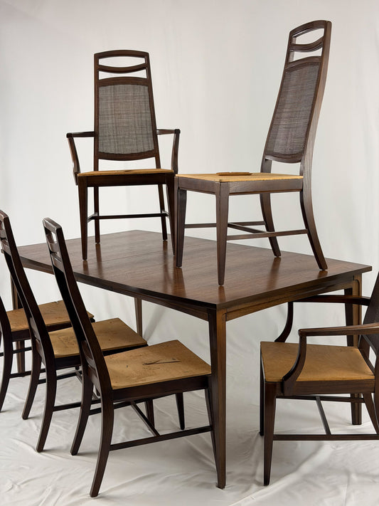 Wooden dining table with matching chairs on a white background
