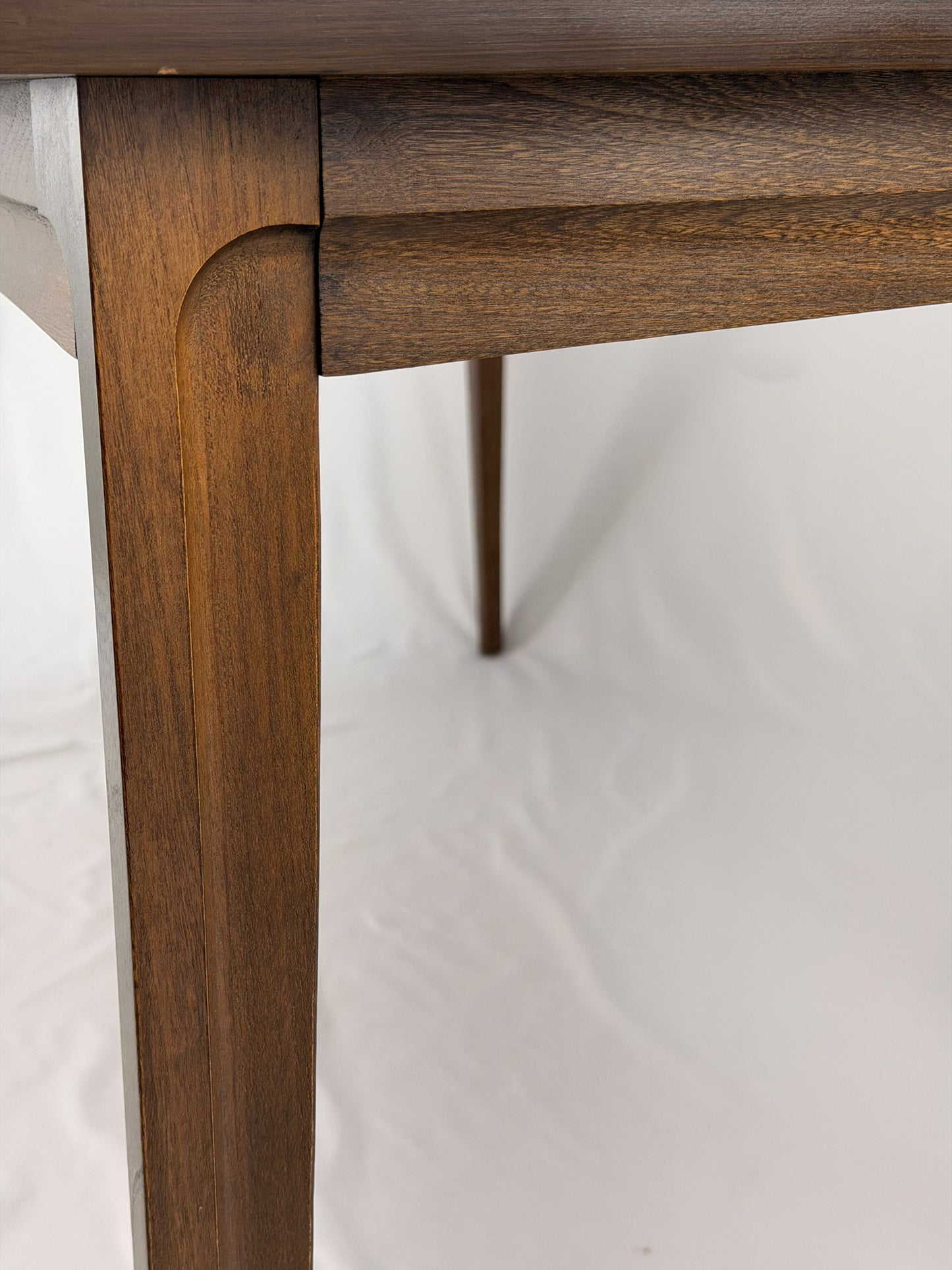 Close-up of a wooden table corner on a white background