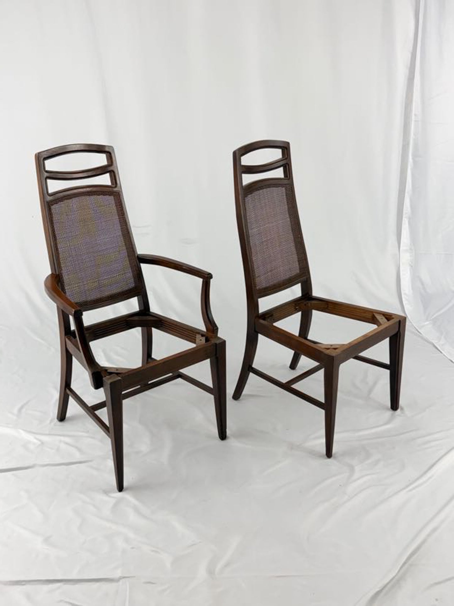 Two wooden chairs with woven backrests on a white background