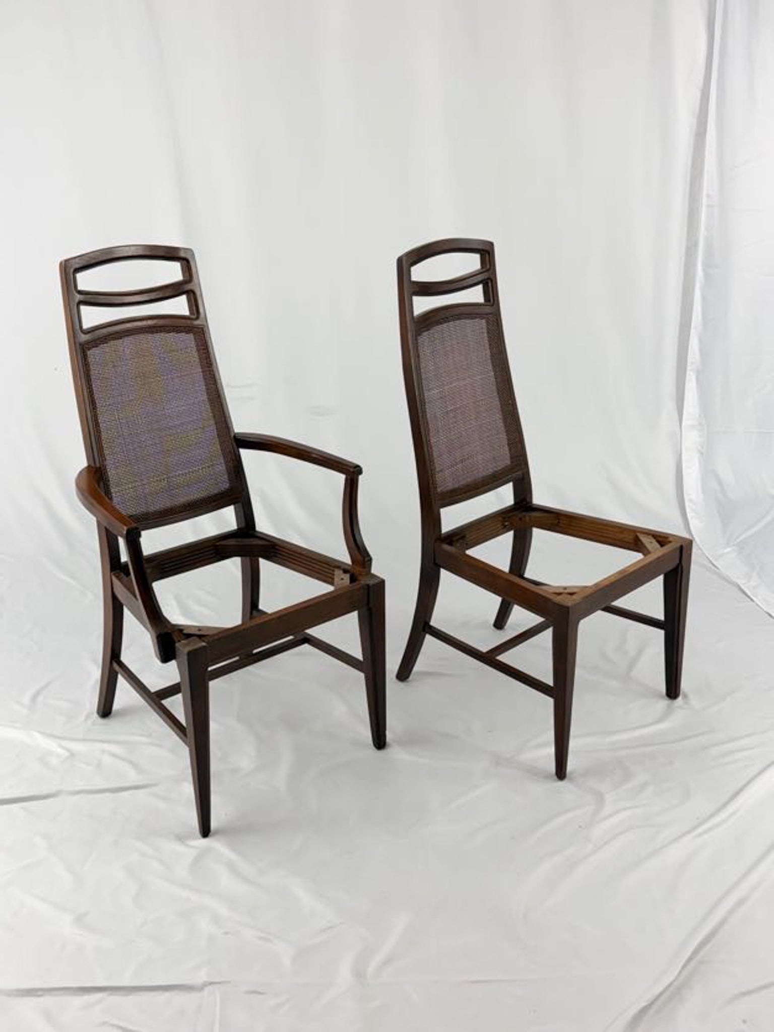 Two wooden chairs with woven backrests on a white background