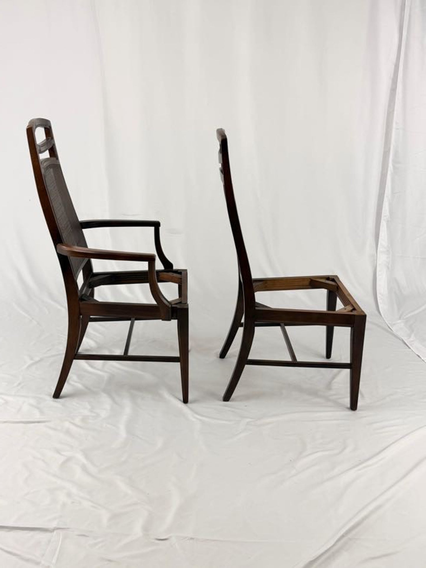 Two wooden chairs with woven backrests on a white background