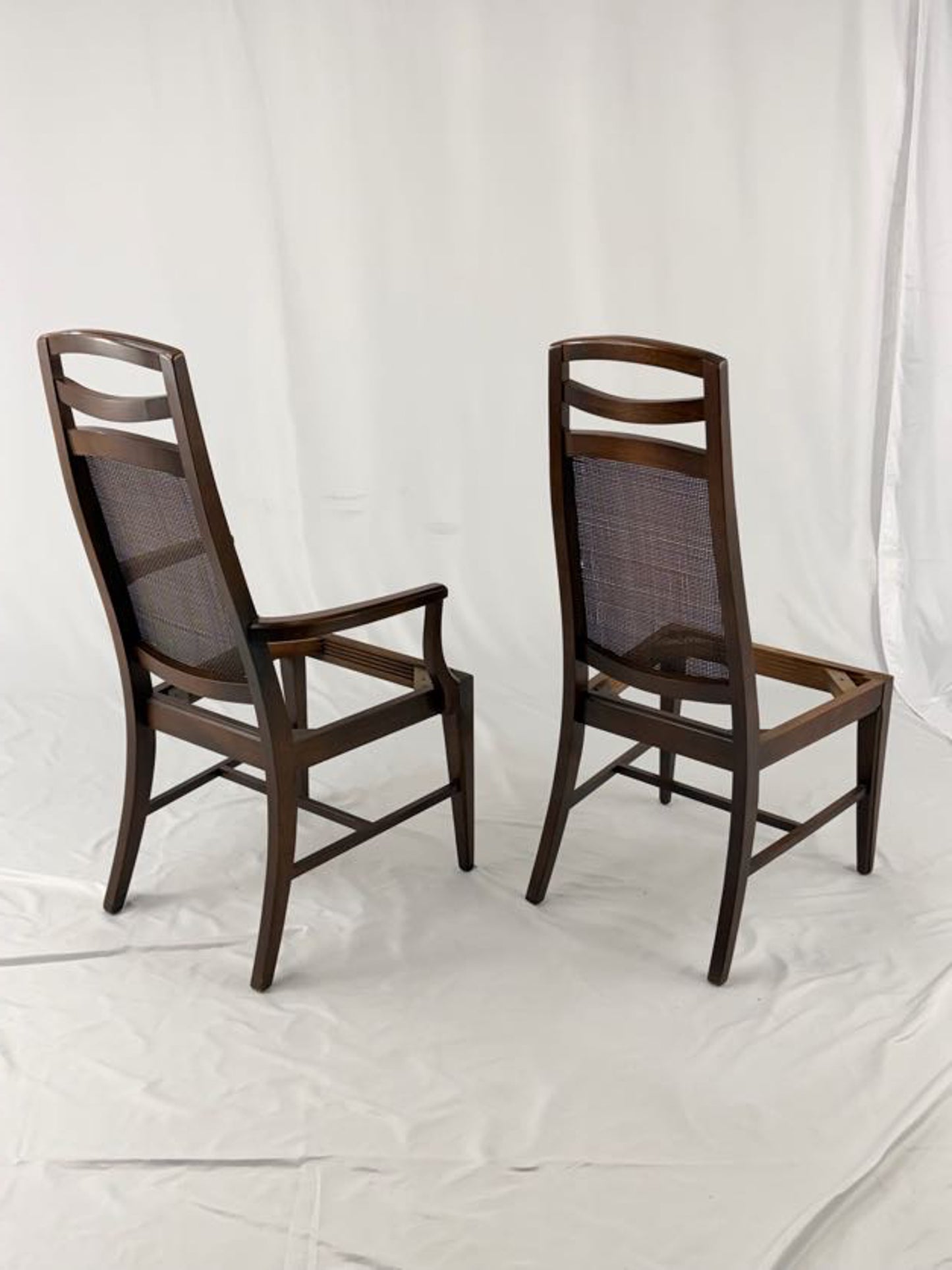 Two wooden chairs with woven backrests on a white background