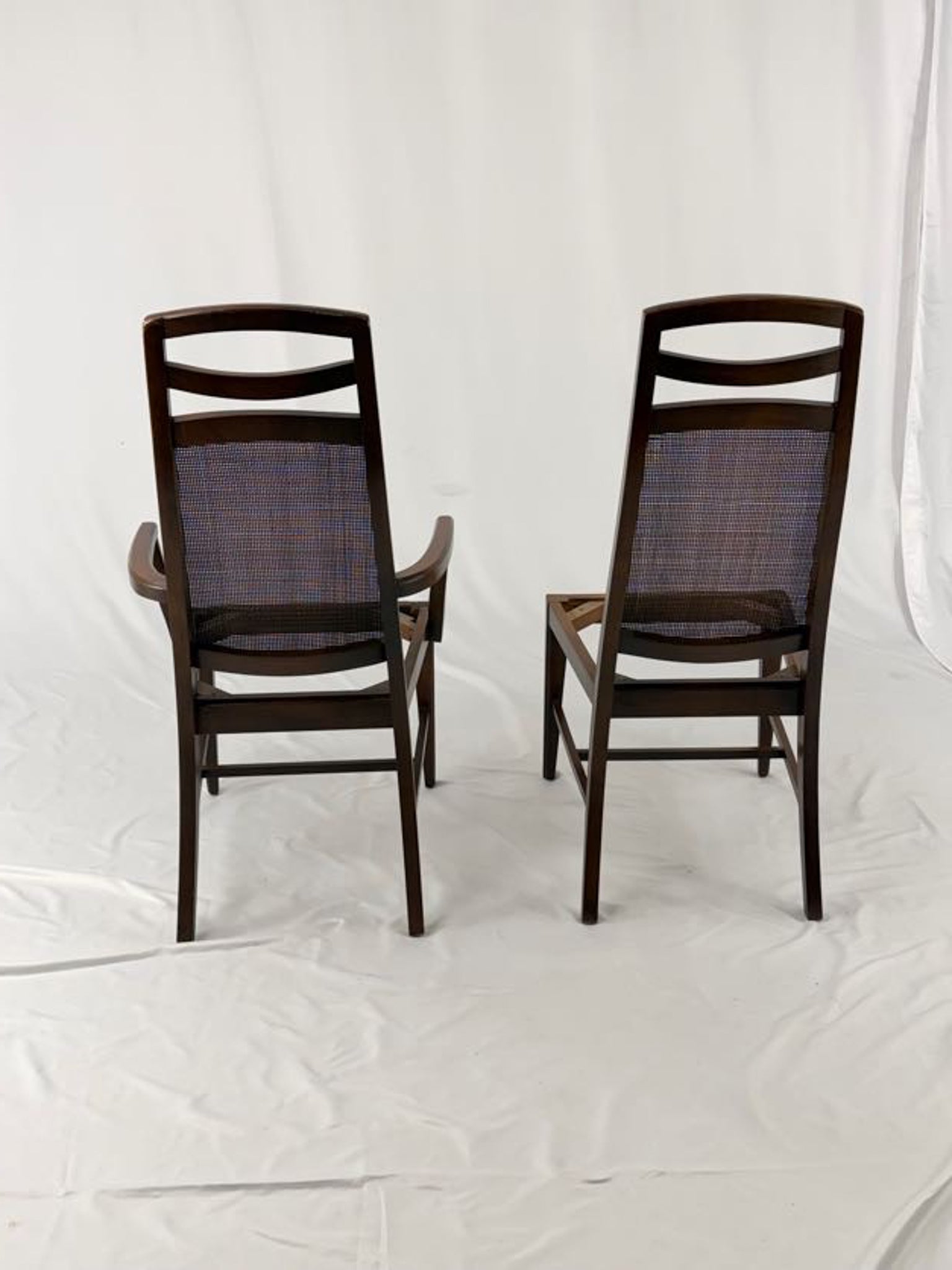 Two wooden chairs with woven backrests on a white background