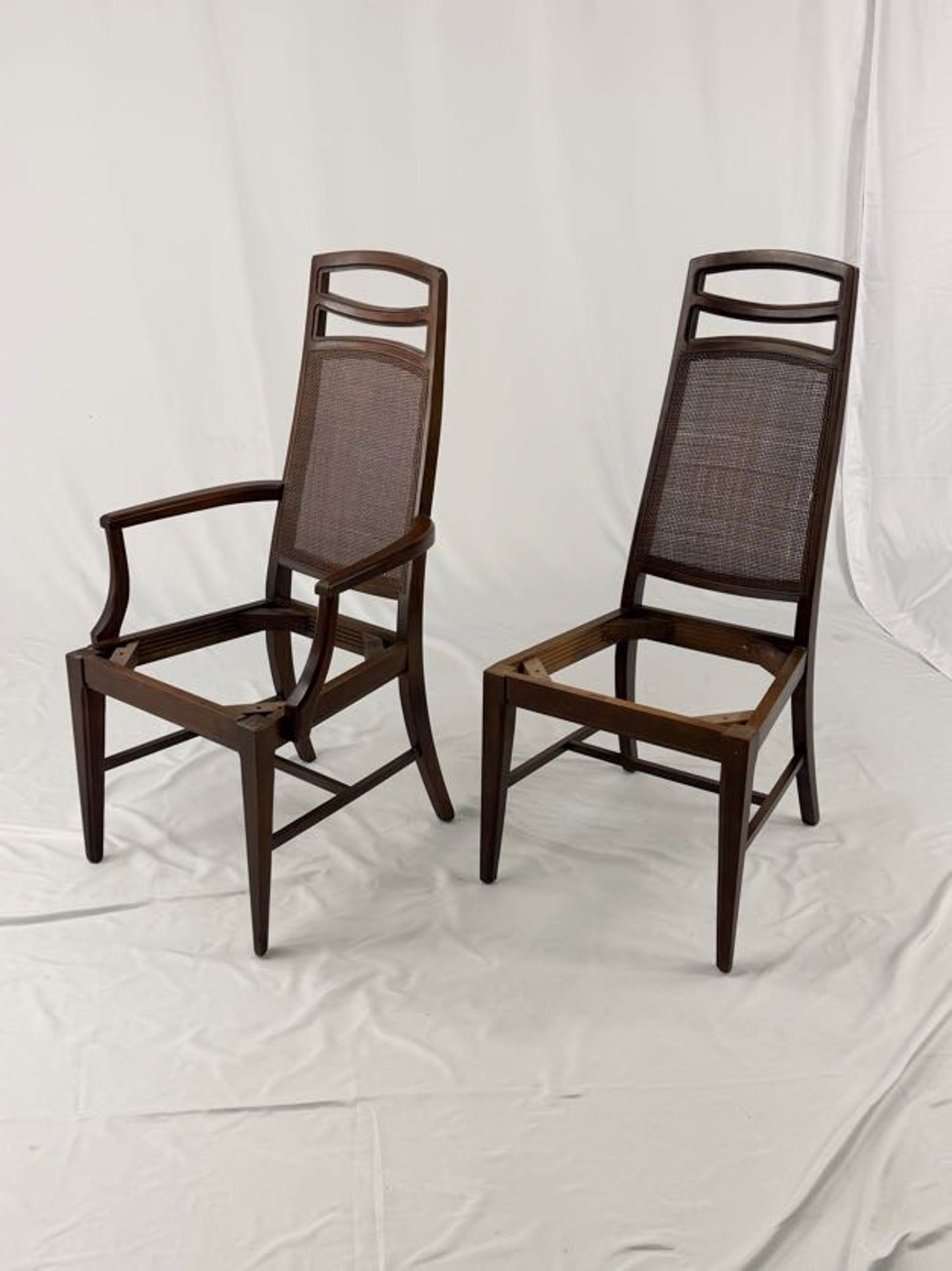 Two wooden chairs with woven seats on a white background