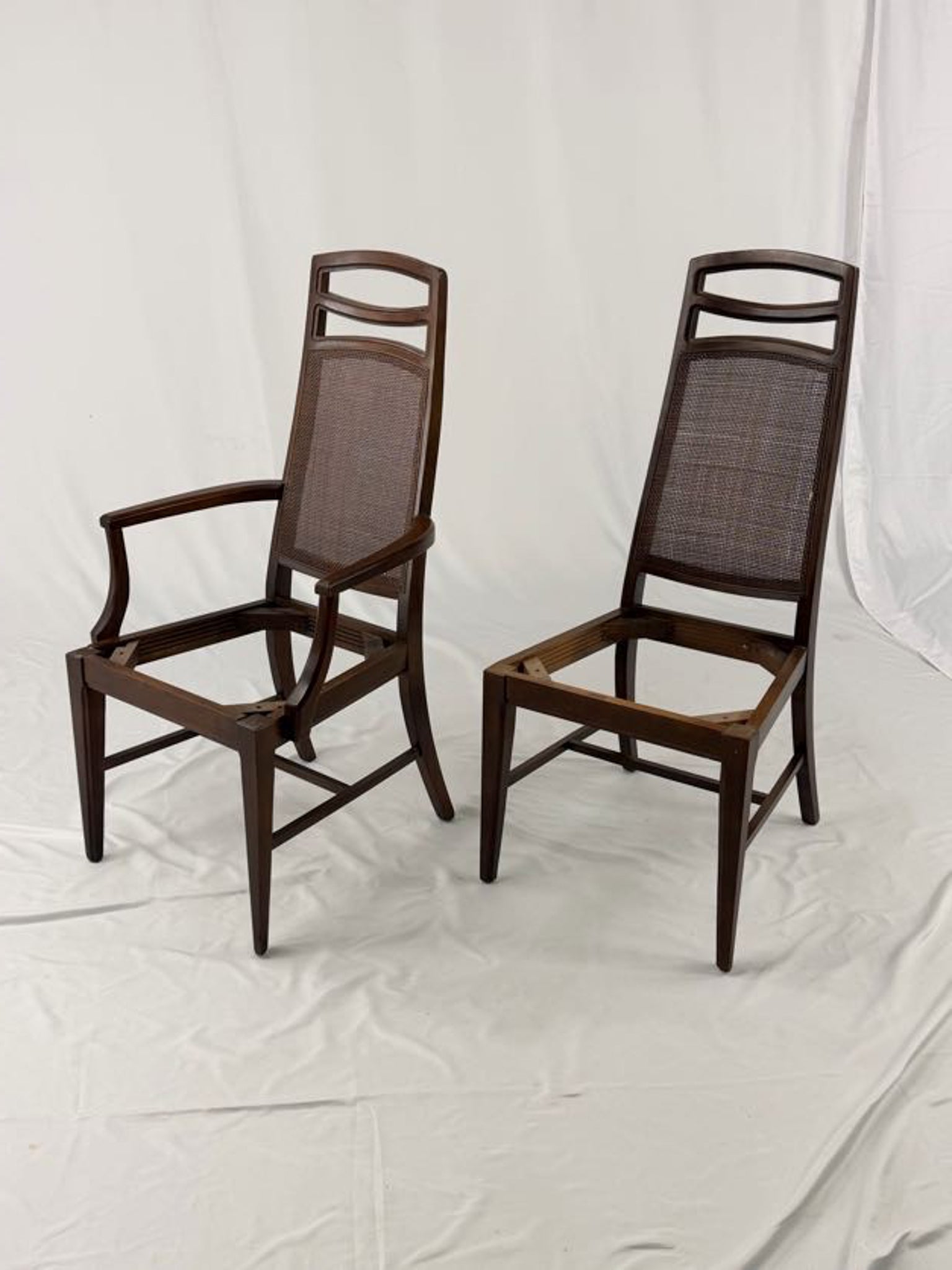 Two wooden chairs with woven seats on a white background