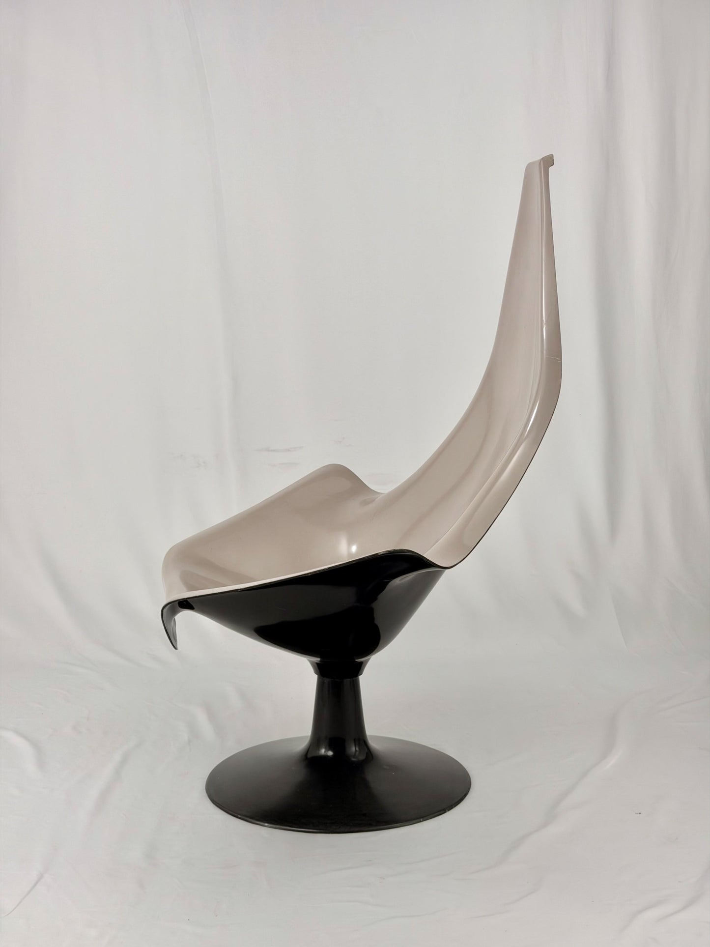 Space Age fiberglass chair with a grey shell and black base on a white background