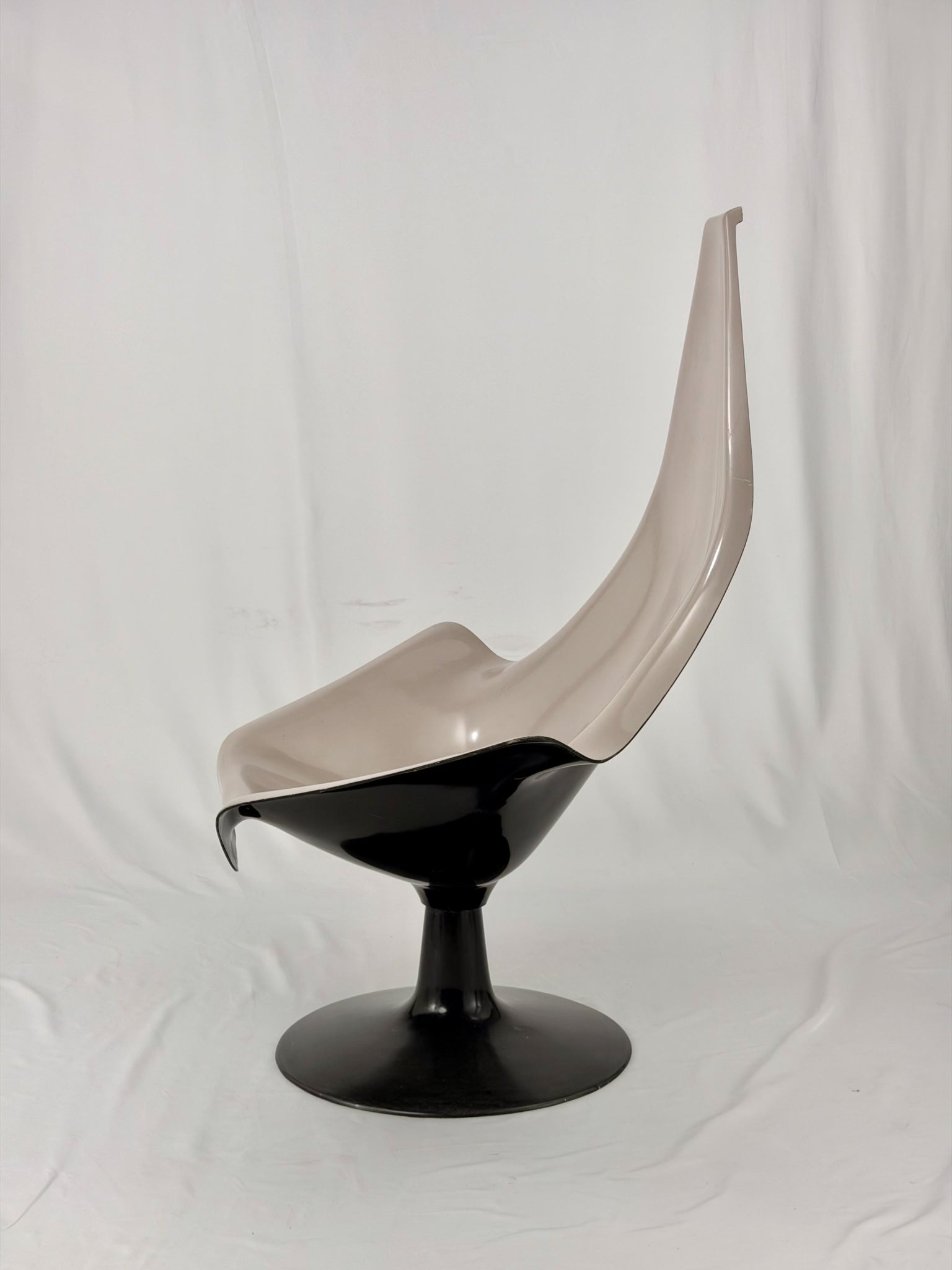 Space Age fiberglass chair with a grey shell and black base on a white background