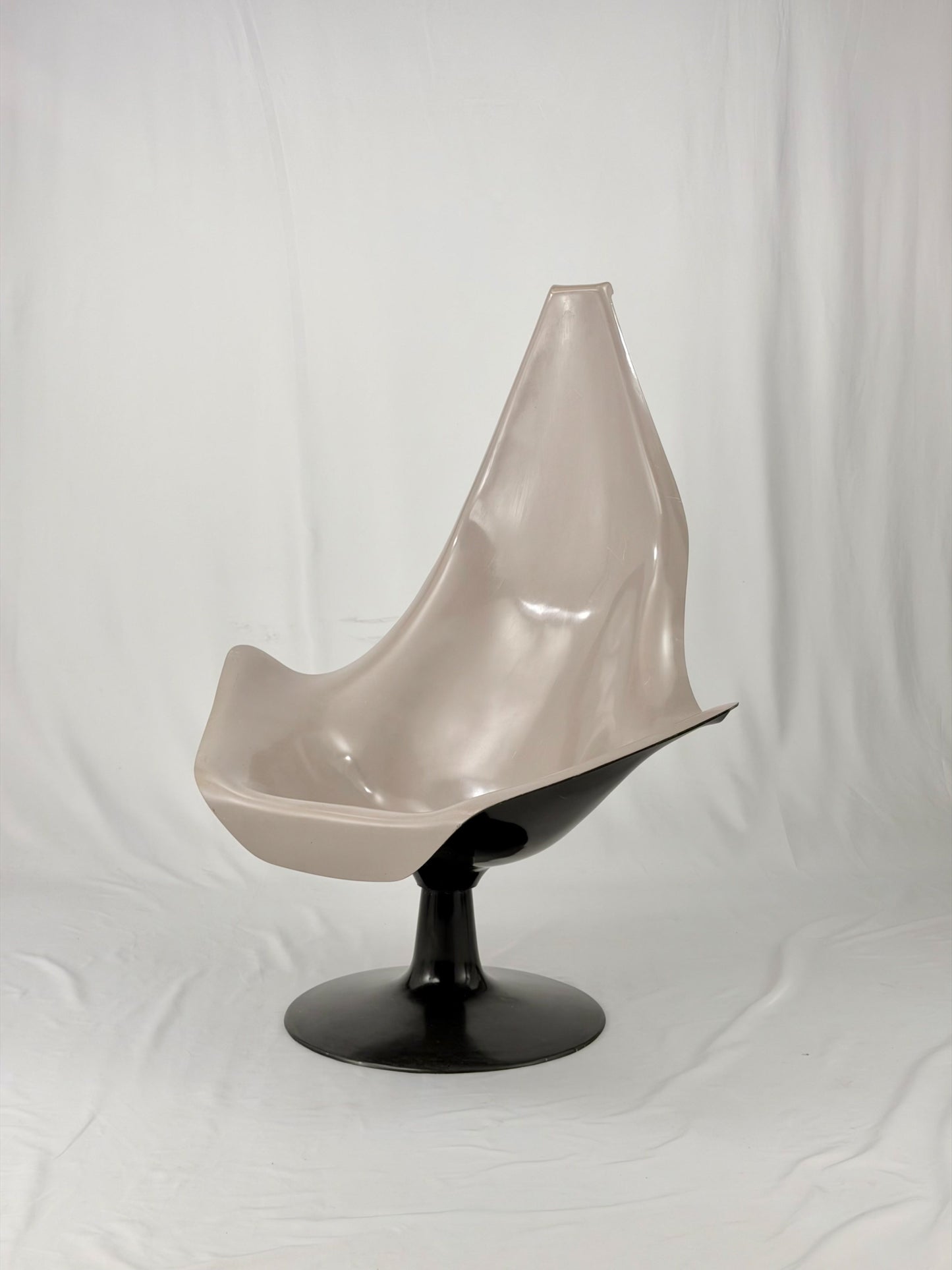 Space Age fiberglass chair with a grey shell and black base on a white background