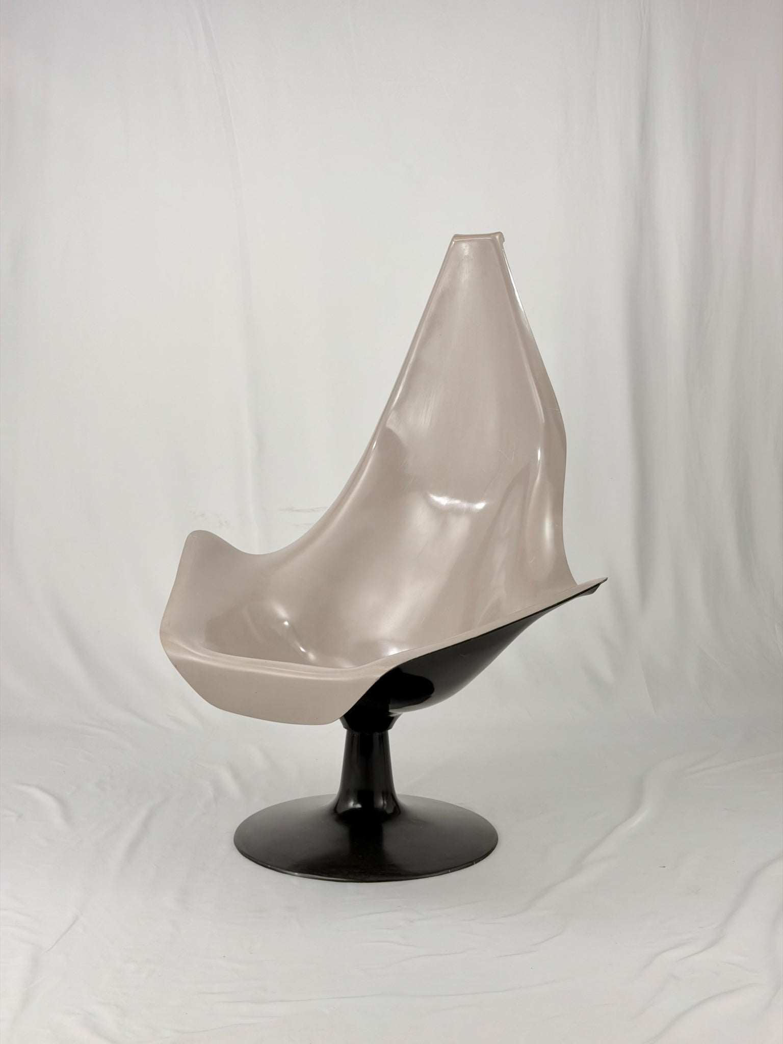 Space Age fiberglass chair with a grey shell and black base on a white background