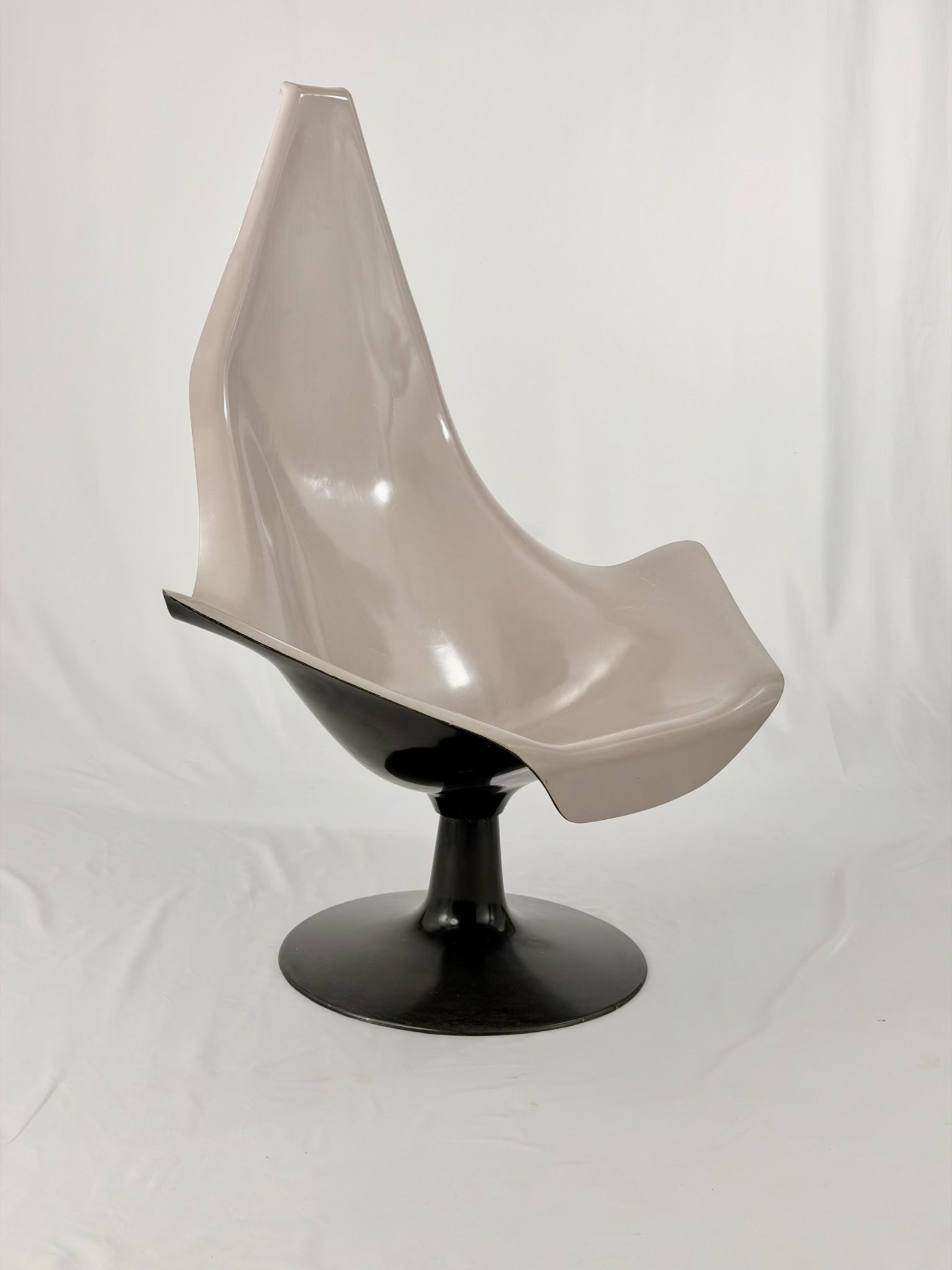 Space Age fiberglass chair with a grey shell and black base on a white background
