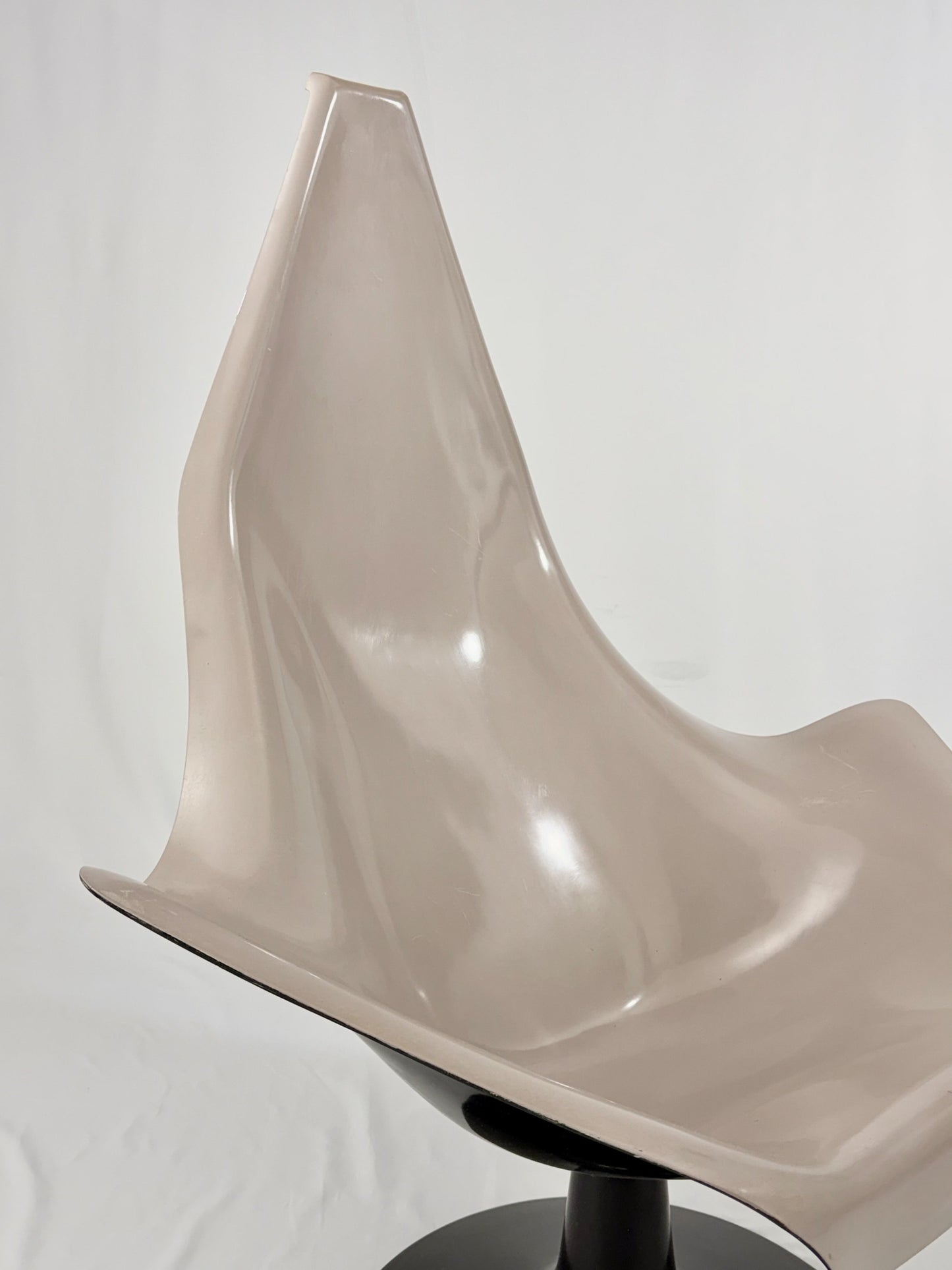 Space Age fiberglass chair with a grey shell and black base on a white background