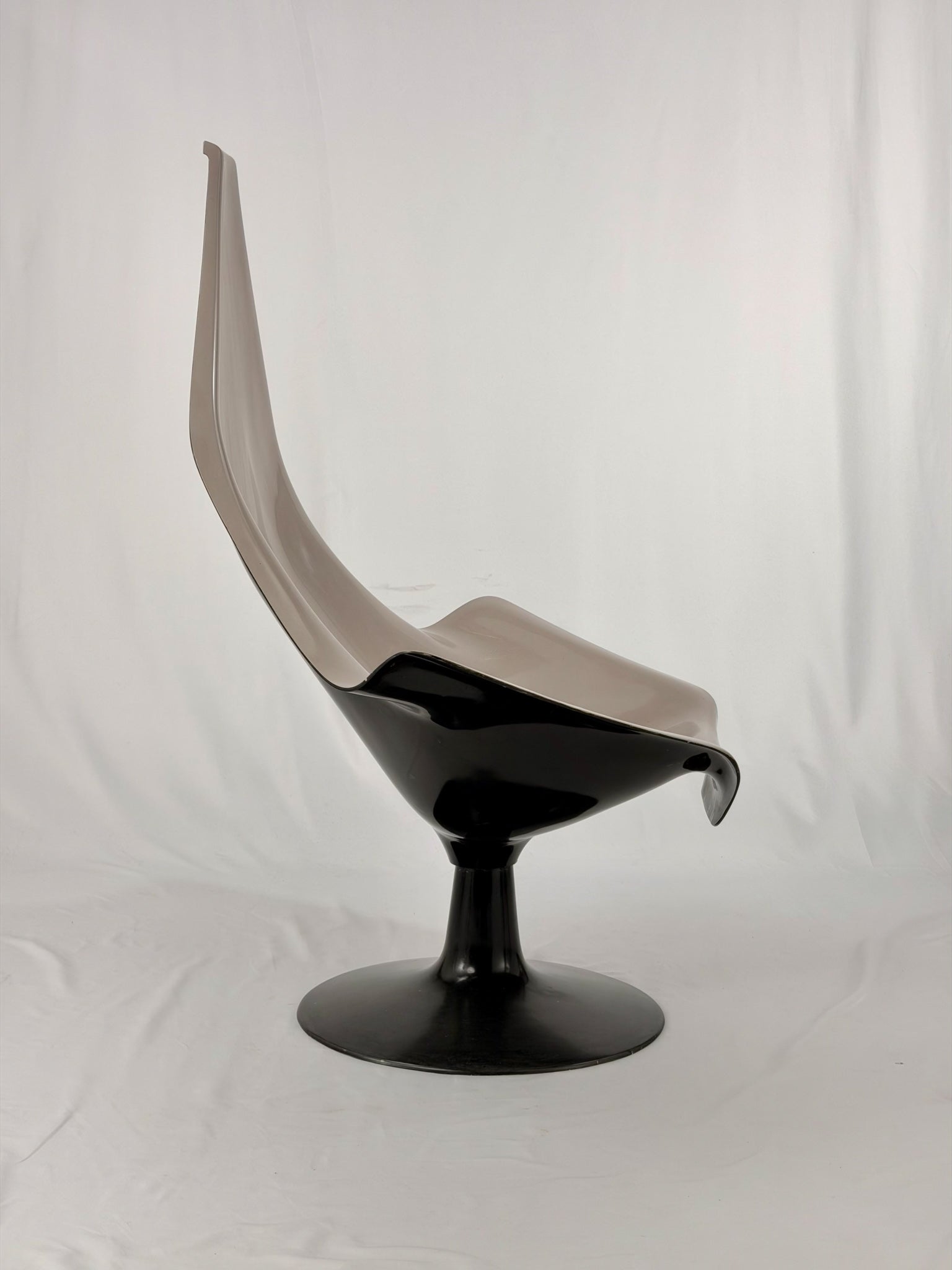 Space Age fiberglass chair with a grey shell and black base on a white background