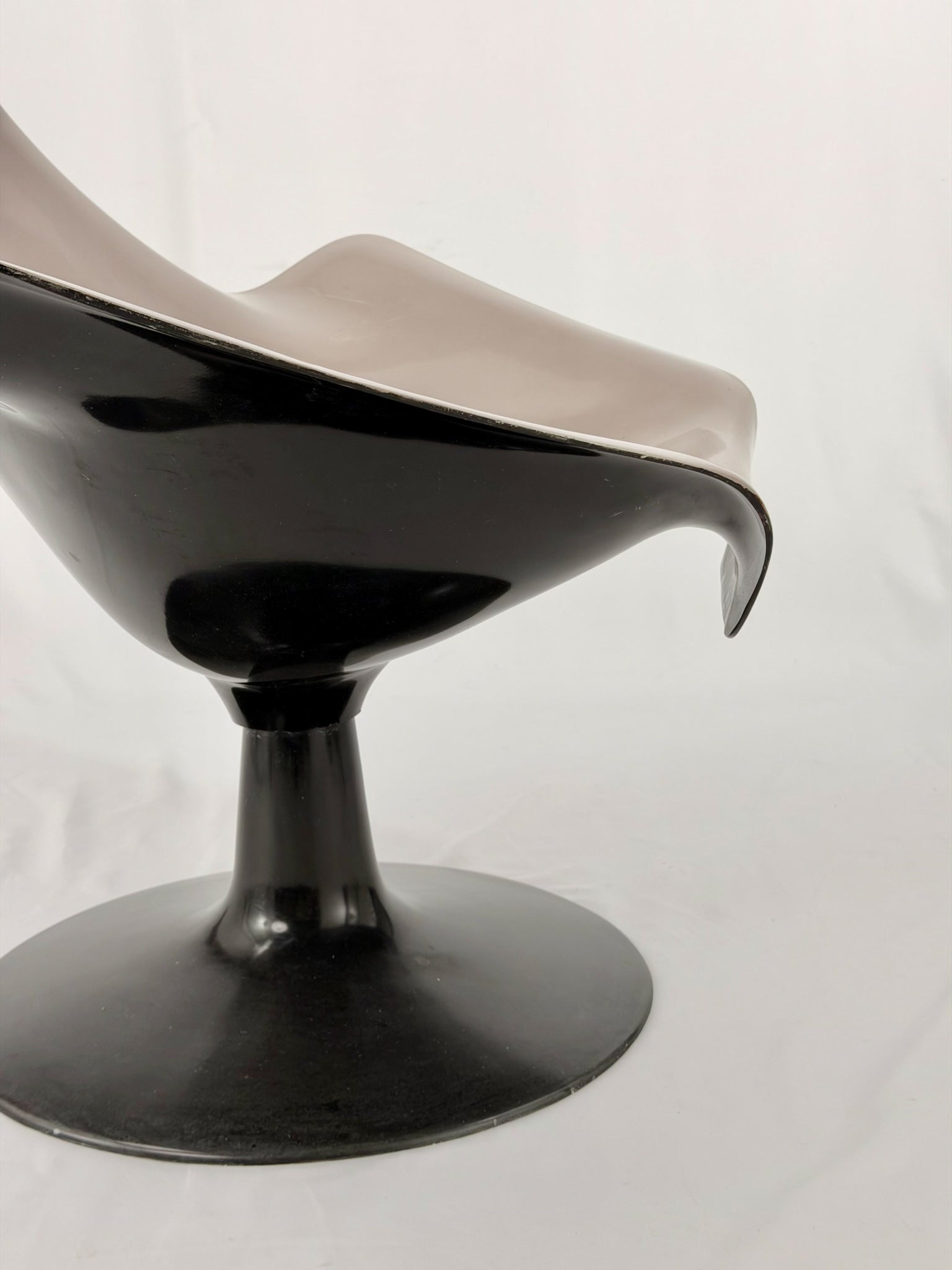 Space Age fiberglass chair with a grey shell and black base on a white background