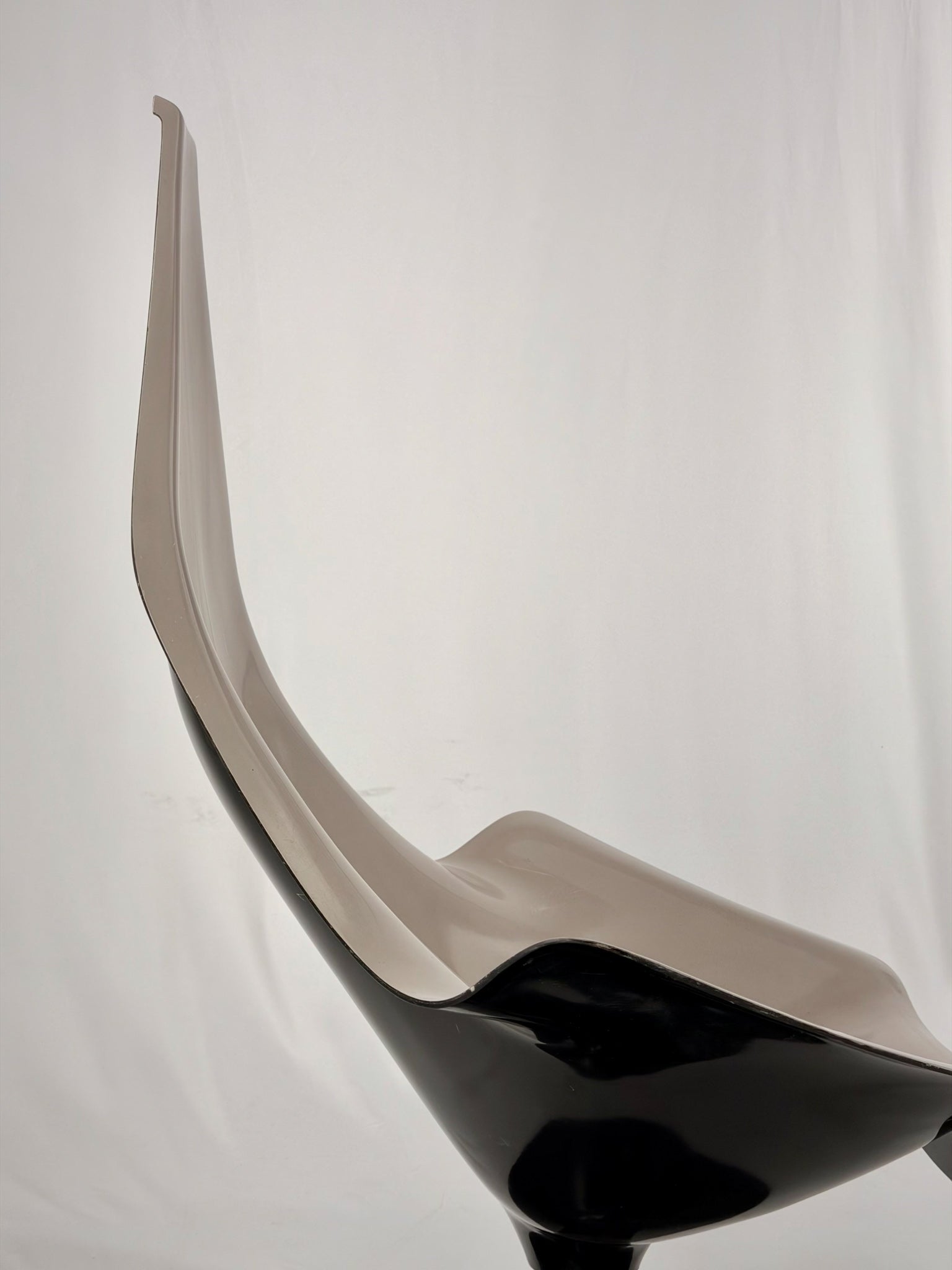 Space Age fiberglass chair with a grey shell and black base on a white background