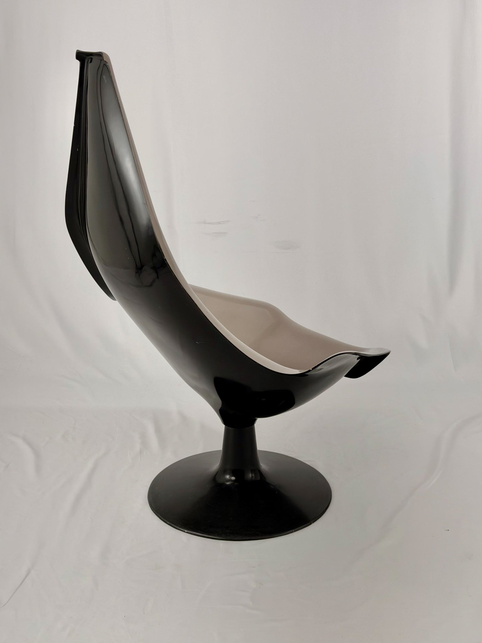 Space Age fiberglass chair with a grey shell and black base on a white background