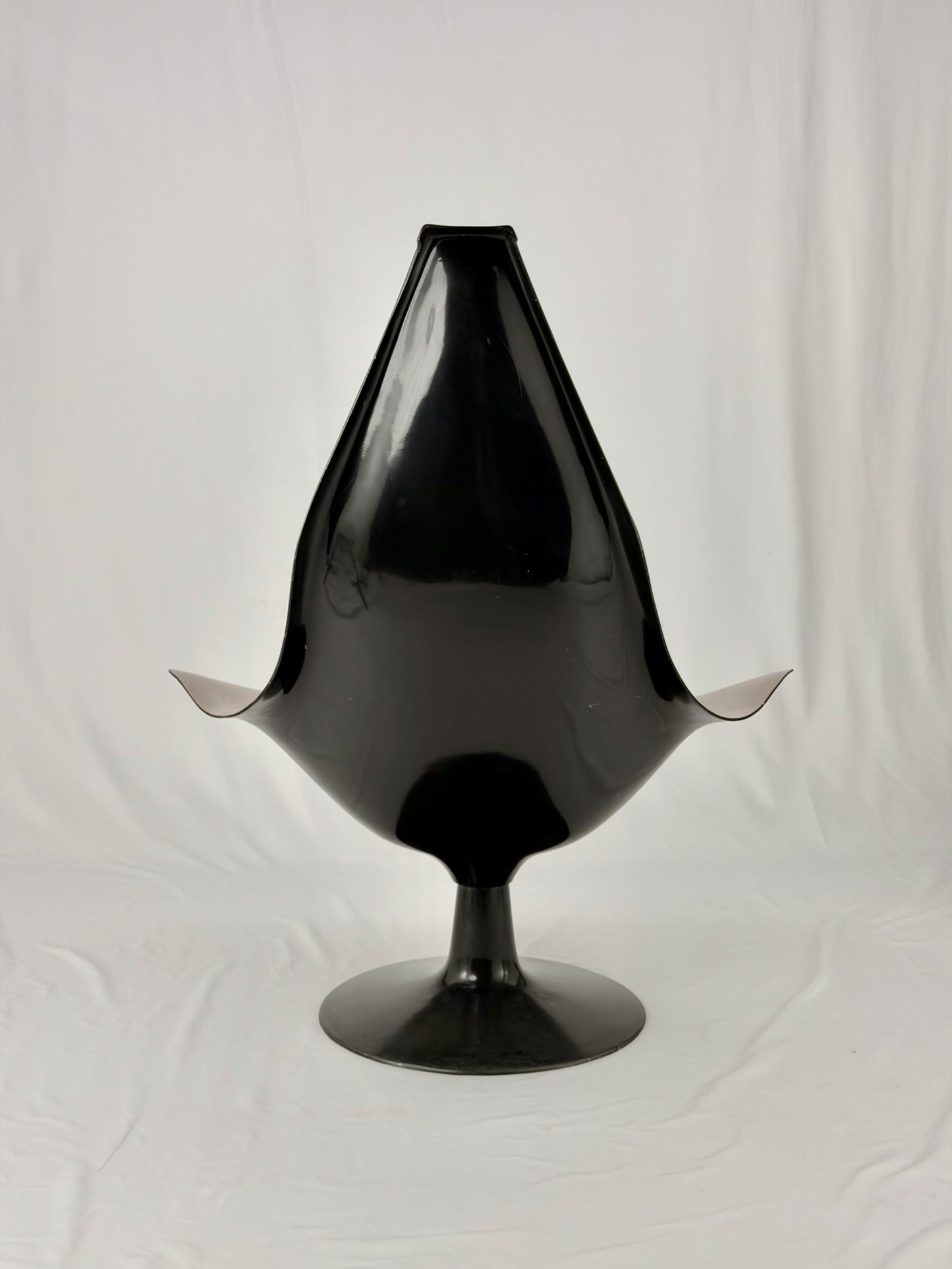 Space Age fiberglass chair with a grey shell and black base on a white background