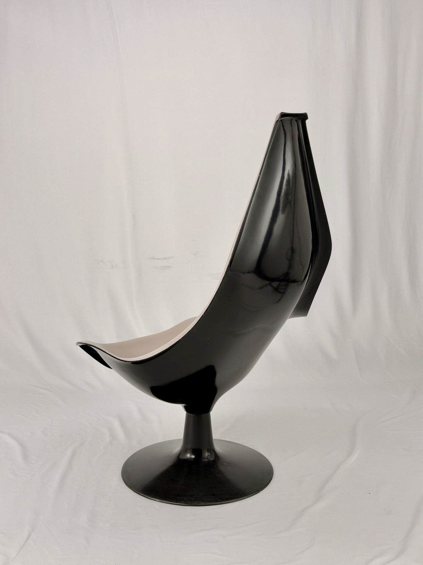 Space Age fiberglass chair with a grey shell and black base on a white background