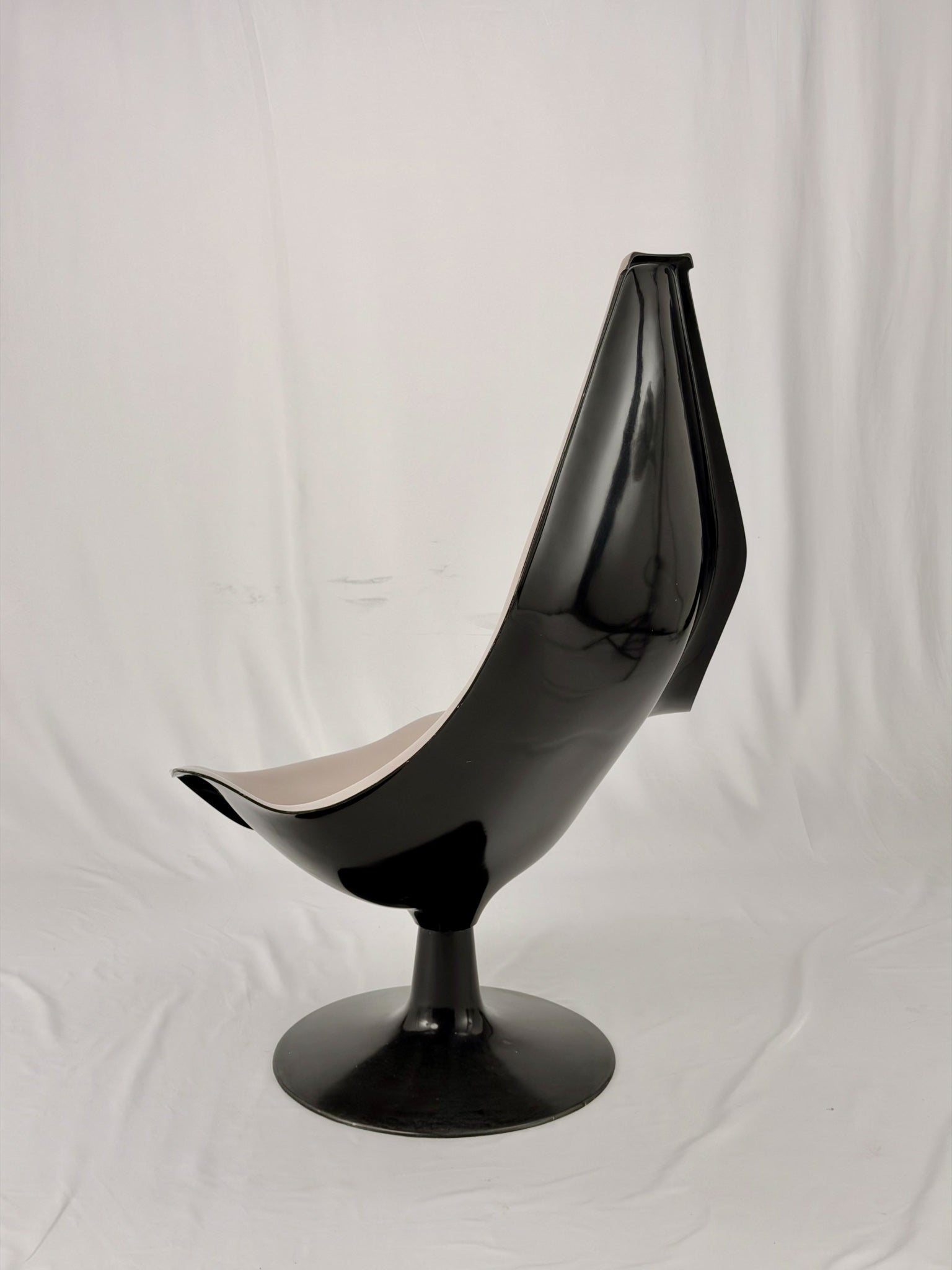 Space Age fiberglass chair with a grey shell and black base on a white background