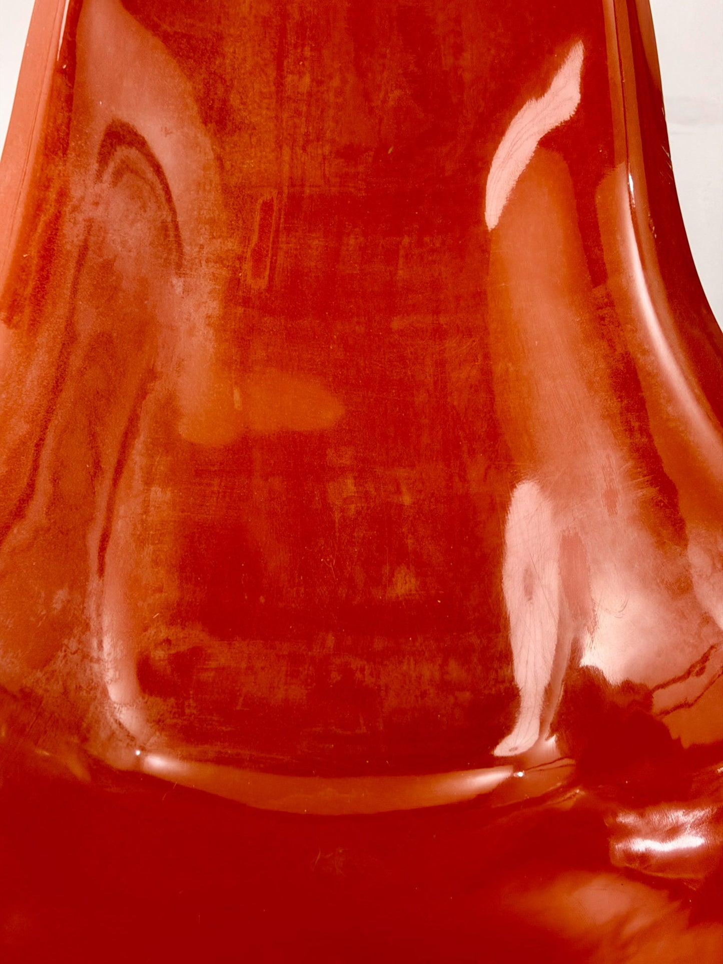 Close up of a Spage Age fiberglass orange chair showing wear marks
