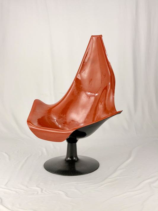 Spage Age fiberglass orange chair with a black base on a white background