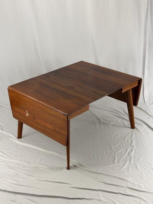 Wooden drop-leaf table on a white background