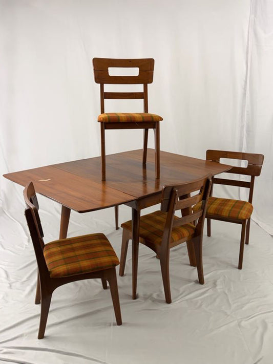 Wooden dining table with four matching chairs on a white background