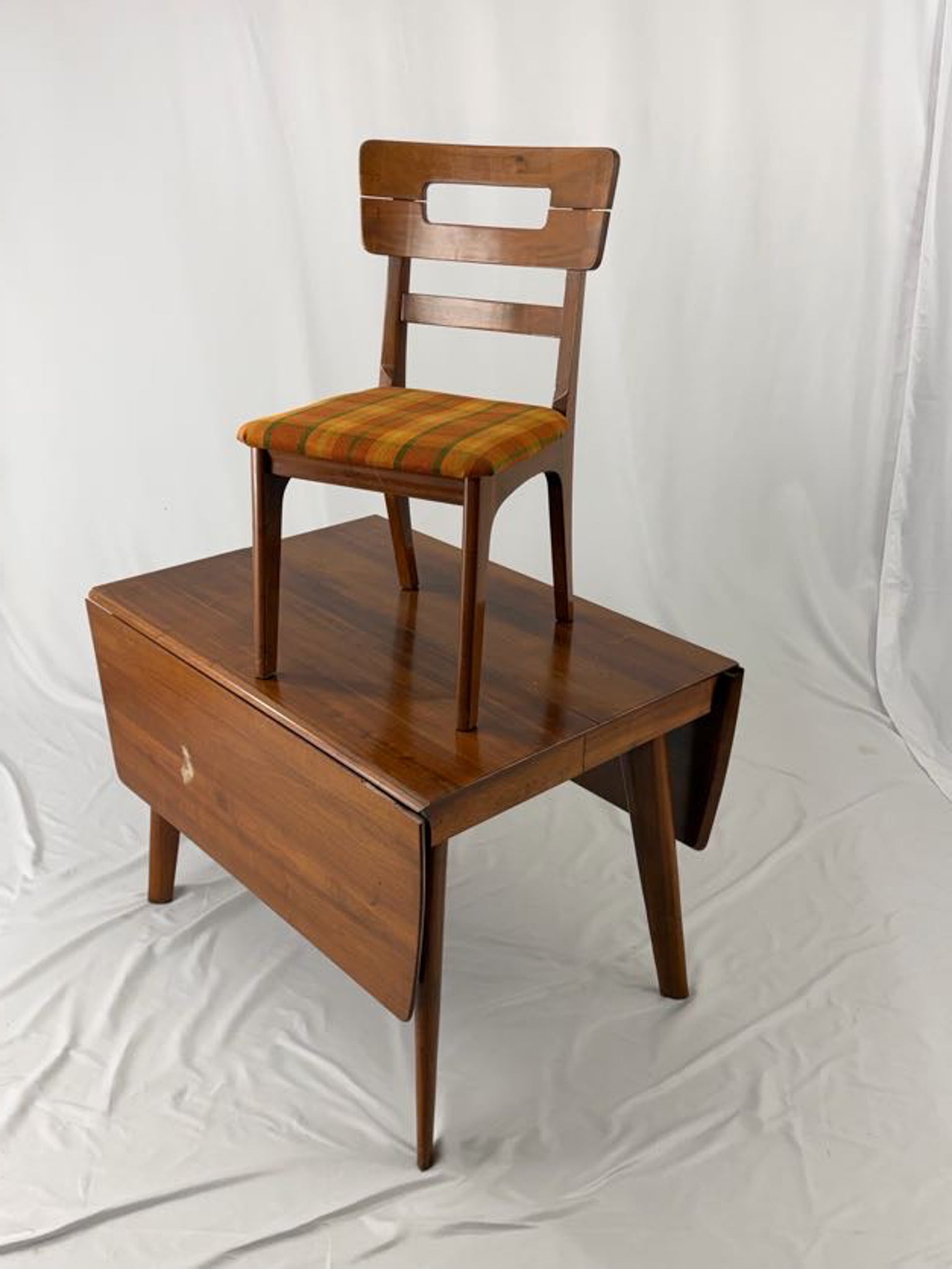 Wooden chair with a seat on top of a wooden table against a white background