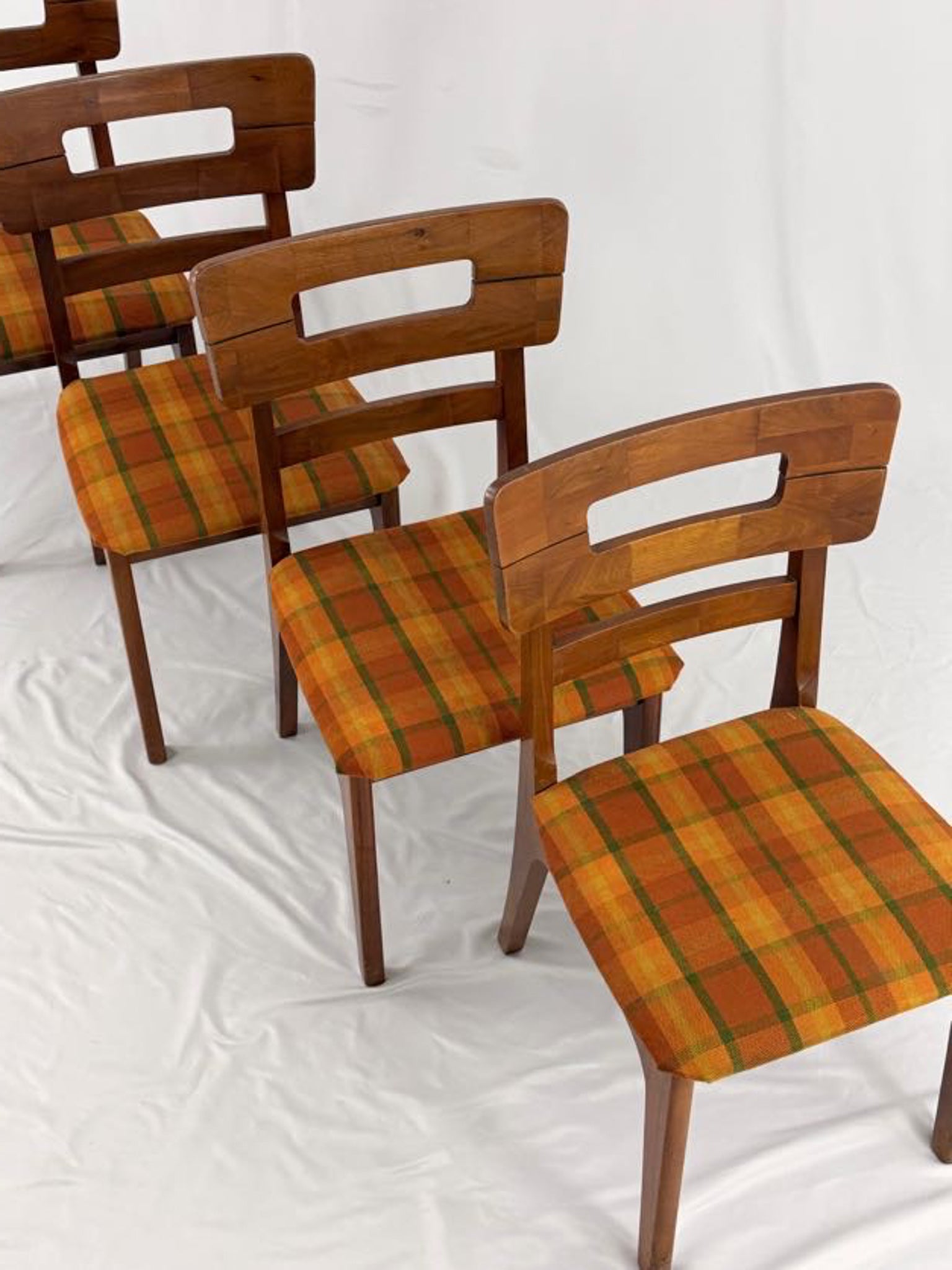 Set of wooden chairs with plaid seats on a white background