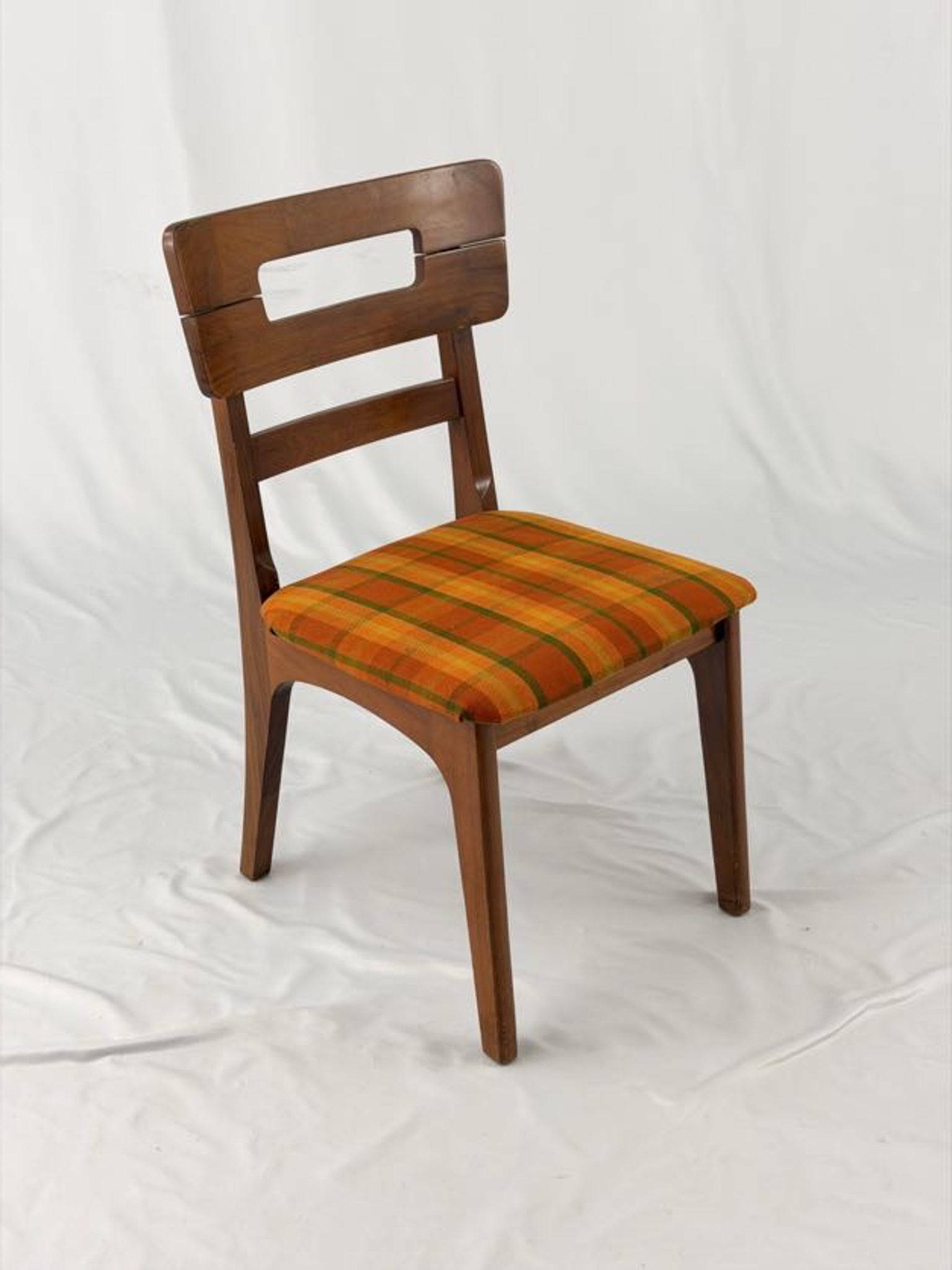 Wooden chair with a striped orange and brown seat on a white background