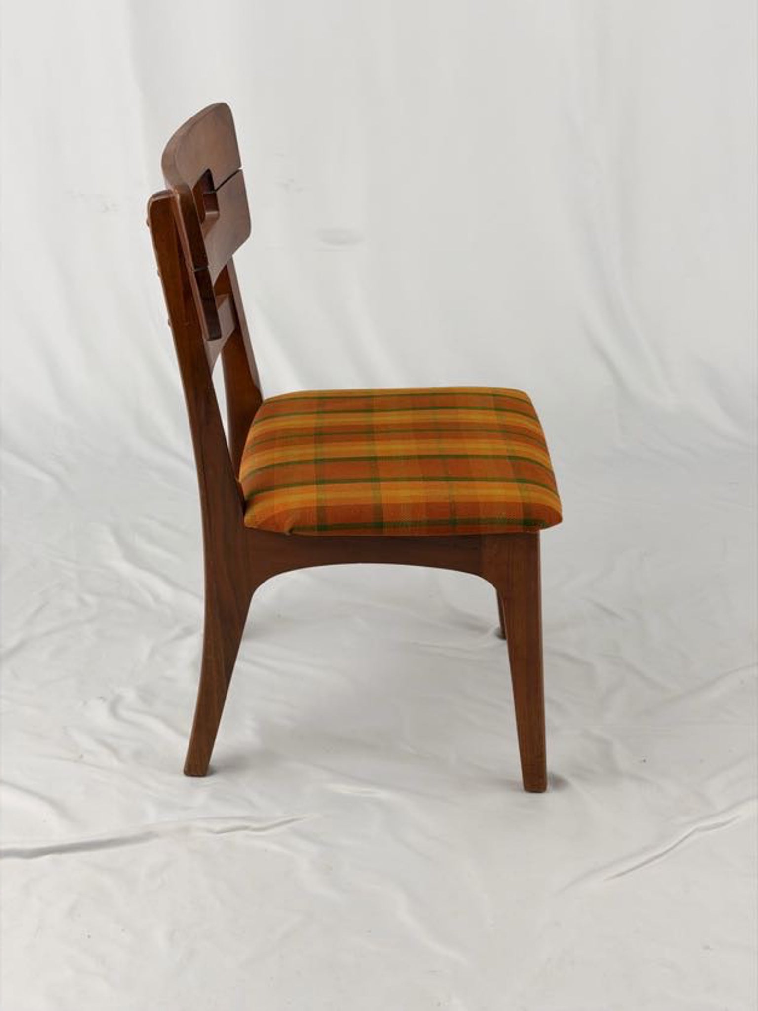 Wooden chair with a striped orange and brown seat on a white background
