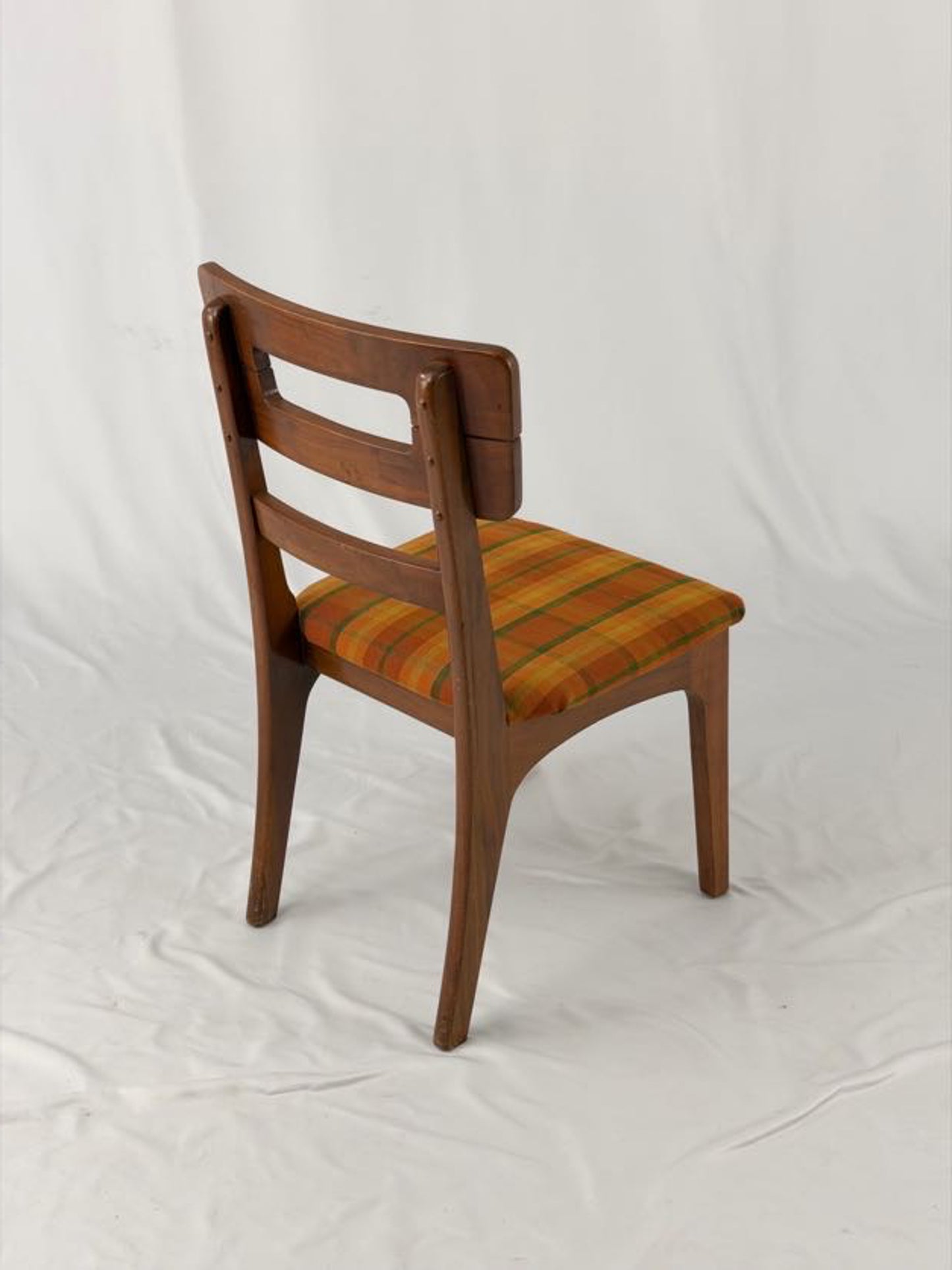 Wooden chair with a striped orange and brown seat on a white background