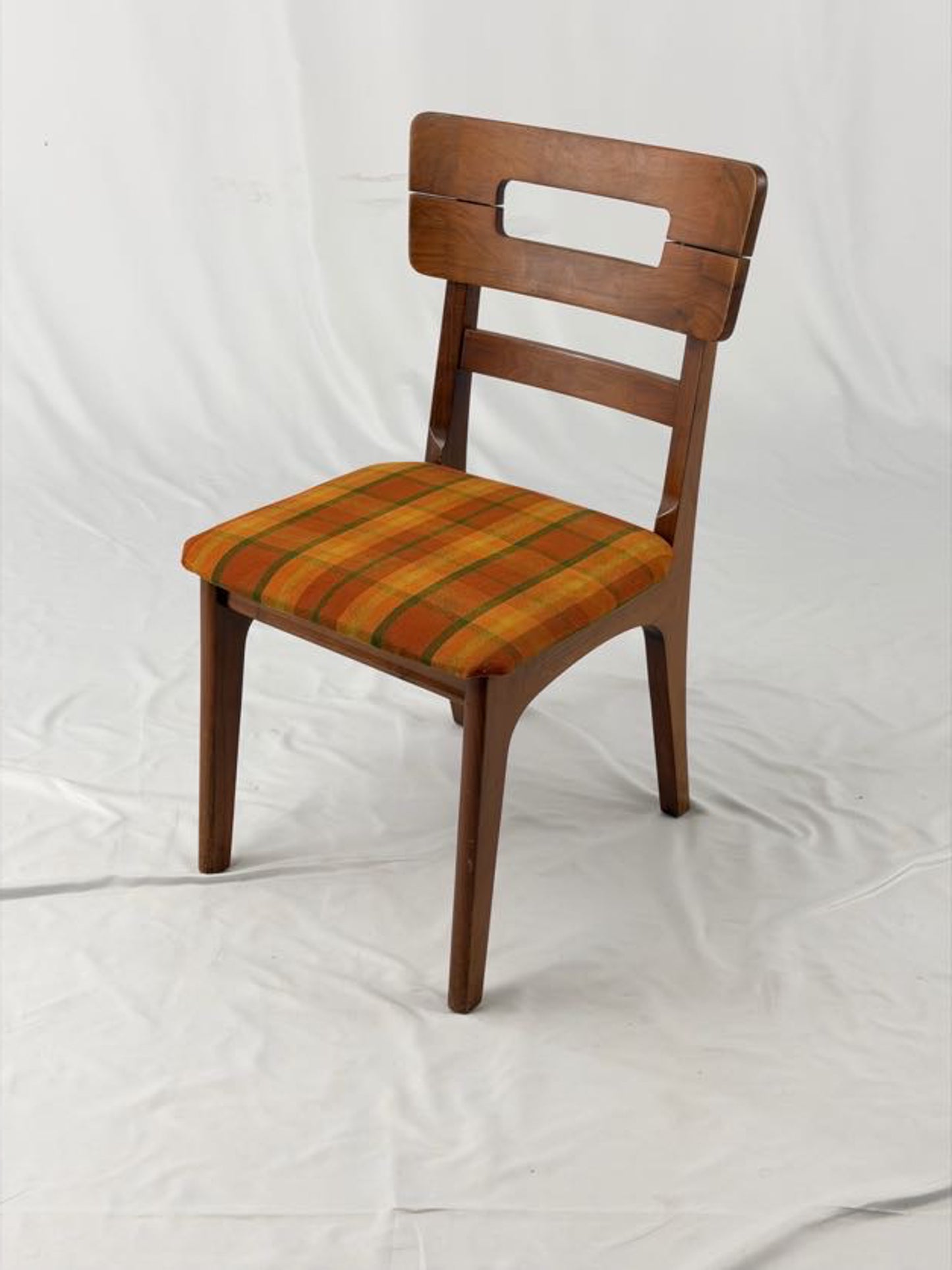 Wooden chair with a striped orange and brown seat on a white background